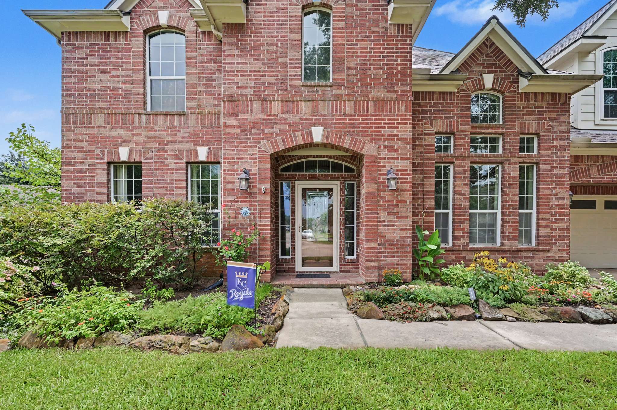 16 of 71. Inviting brick home with spacious front yard, large windows, and welcoming entrance near local amenities.
