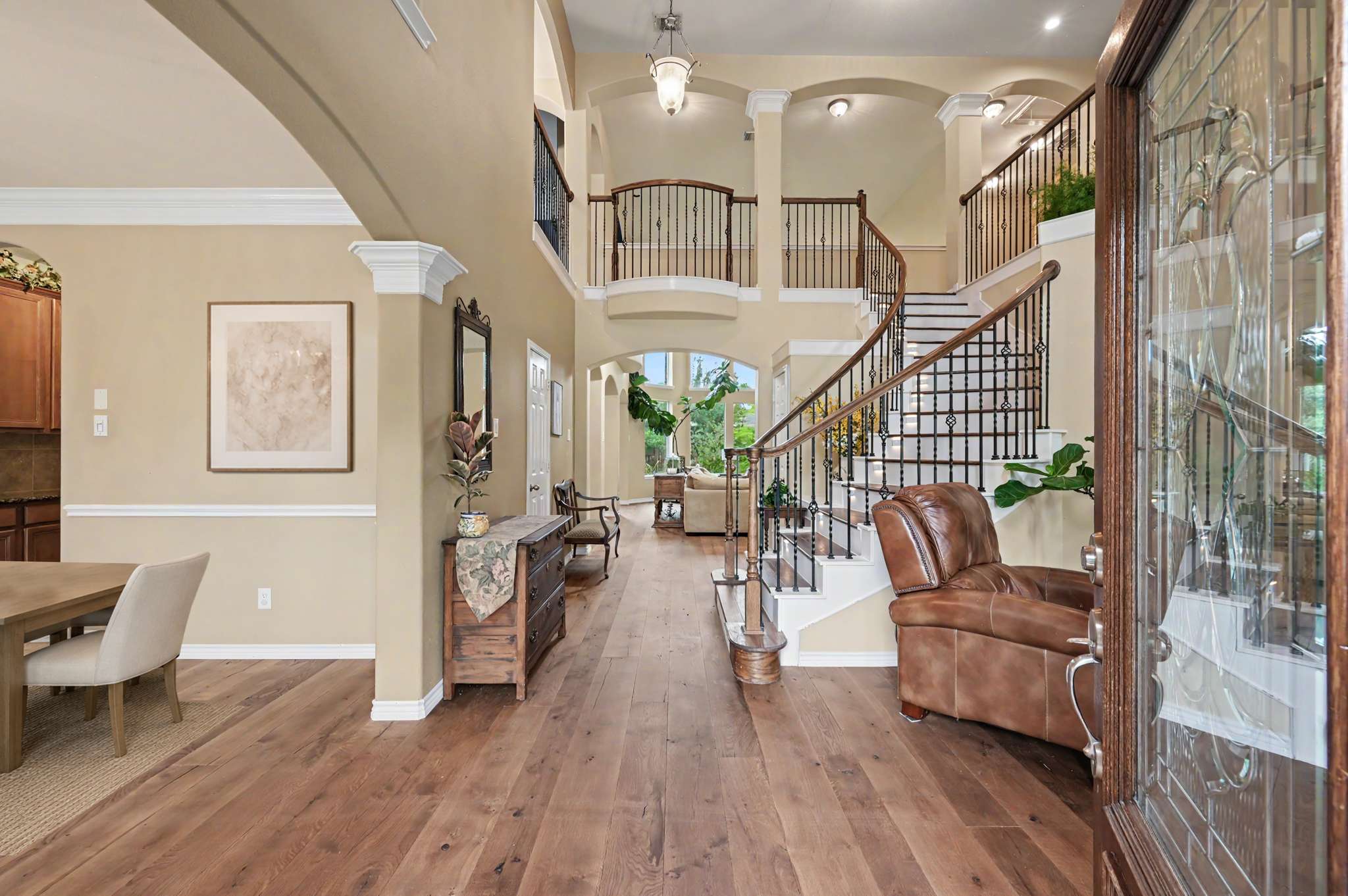 18 of 71. Spacious entryway featuring inviting high ceilings, rich wood flooring, and a striking staircase centerpiece.