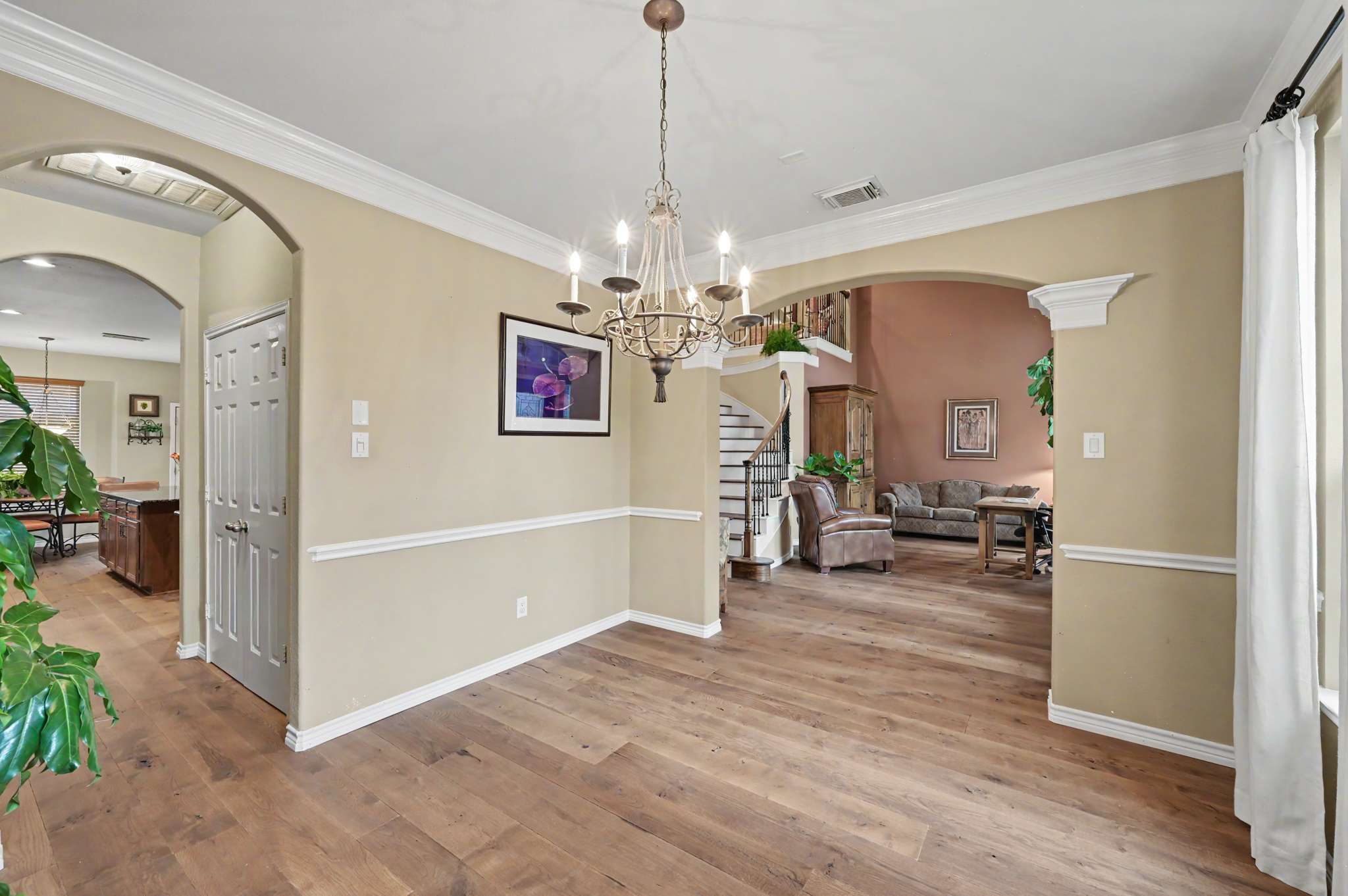 24 of 71. Inviting entryway with beautiful hardwood floors and archways, leading to spacious living areas filled with natural light.