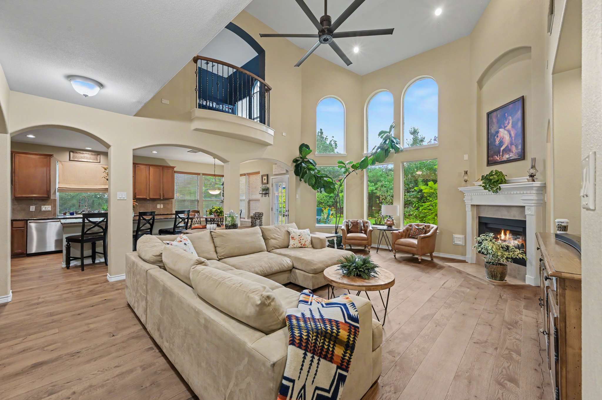 4 of 71. Spacious living area features high ceilings, abundant natural light, and a cozy fireplace for gatherings.