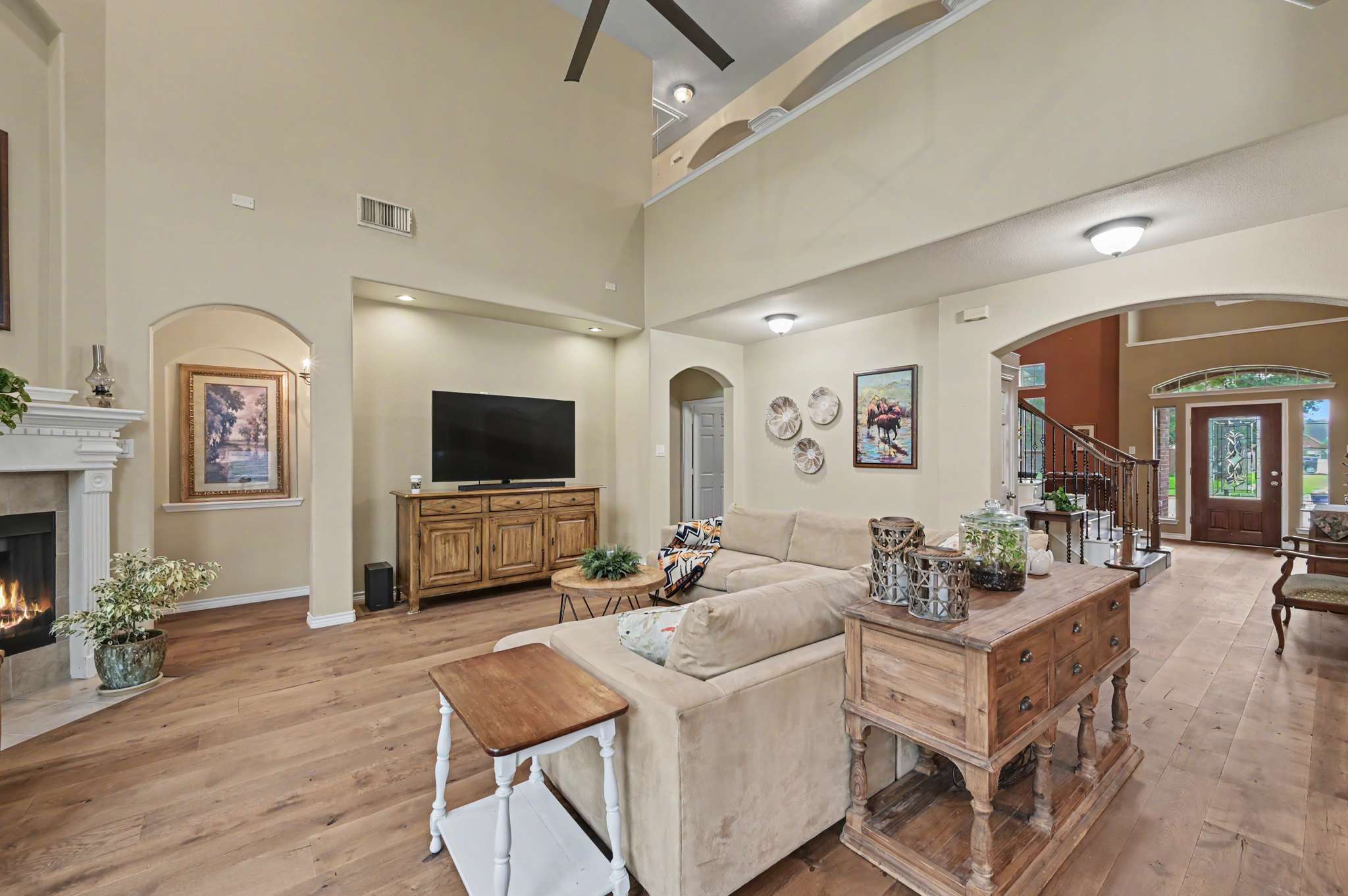 28 of 71. Spacious living area with high ceilings, a cozy fireplace, and abundant natural light throughout.