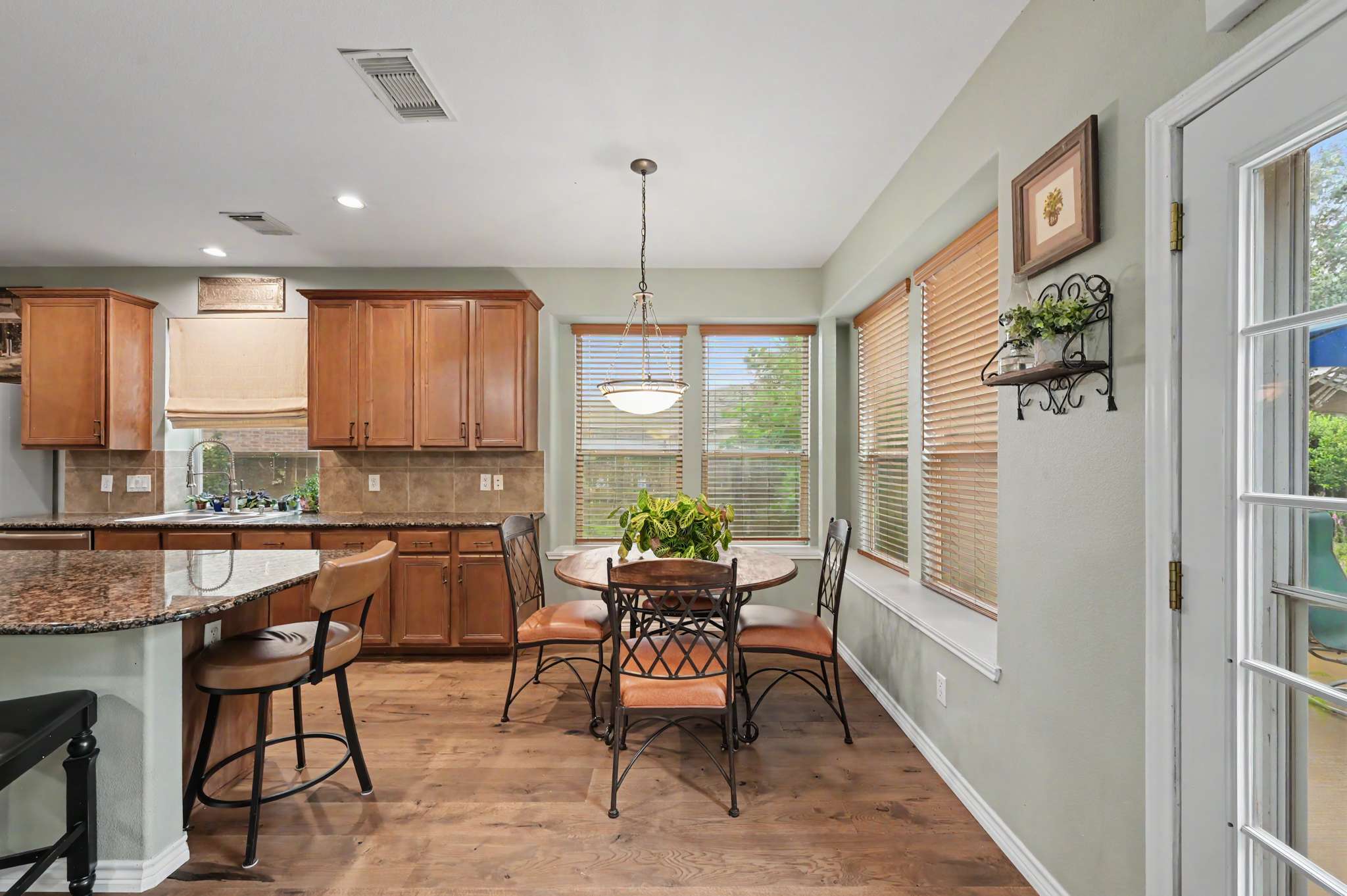 30 of 71. Bright and inviting kitchen features modern appliances, rich cabinetry, and a cozy dining space with natural light.