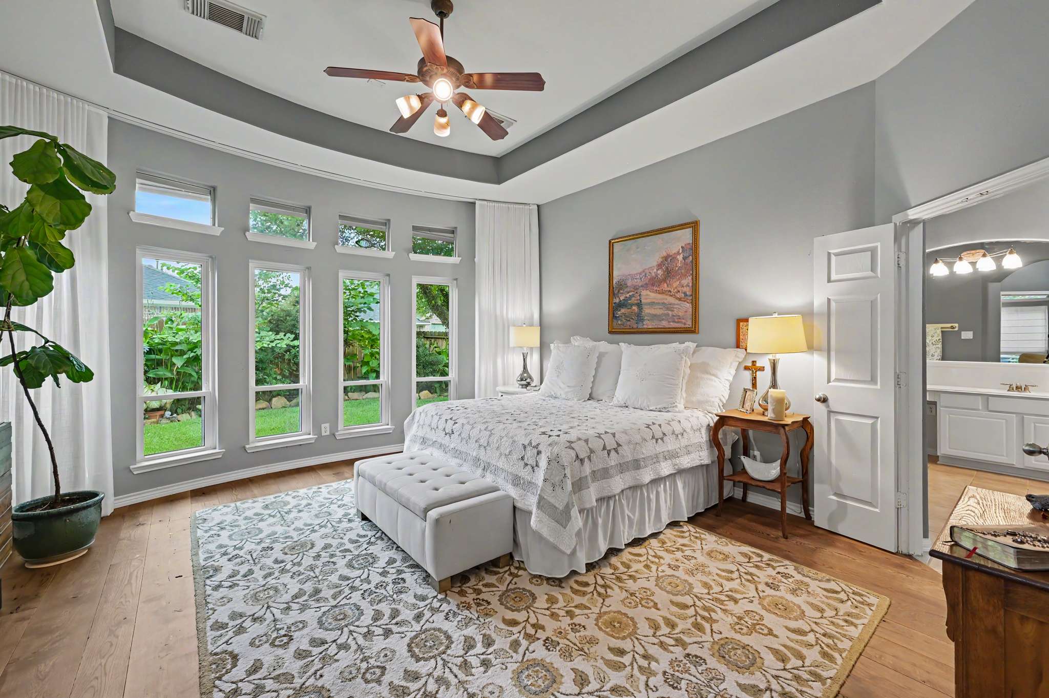 7 of 71. Spacious bedroom featuring large windows, lush views, and a cozy sitting area for relaxation.