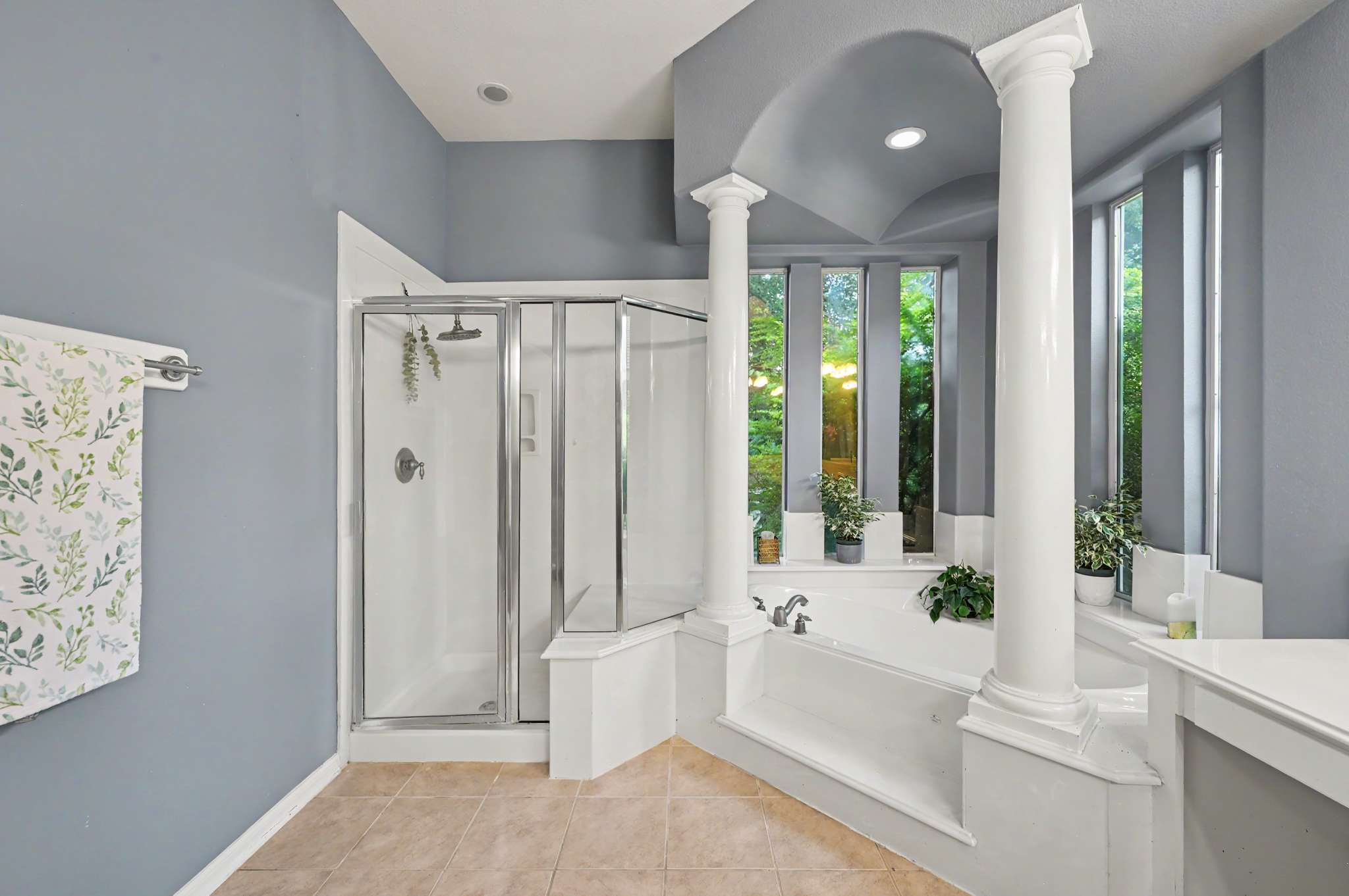 39 of 71. Bright and spacious bathroom featuring a walk-in shower, soaking tub, and large windows for natural light.