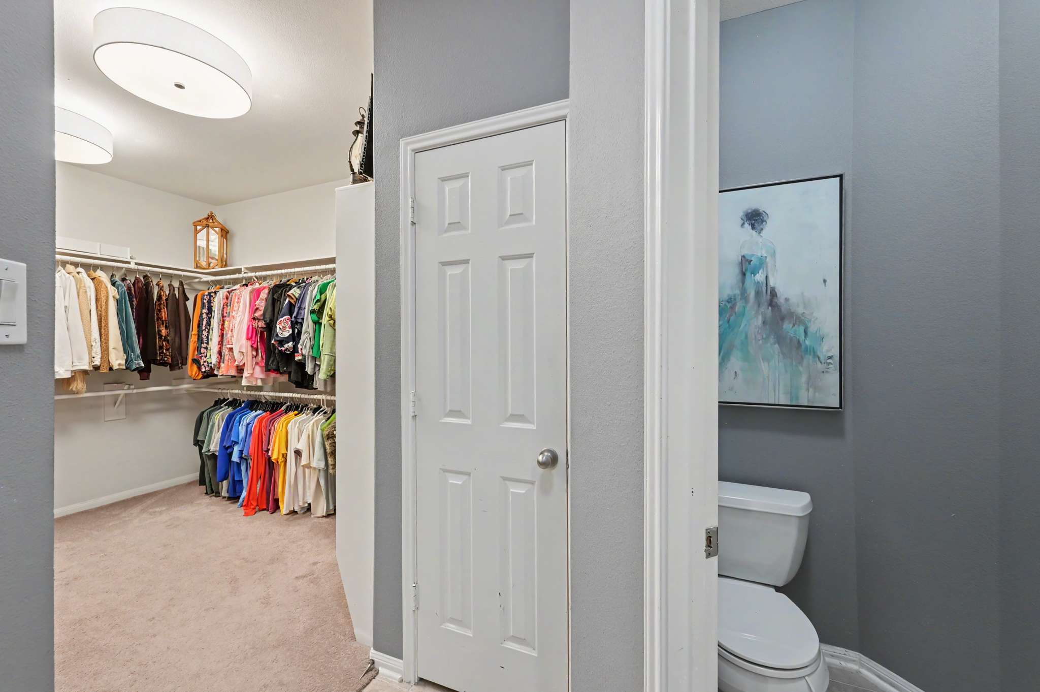 40 of 71. Spacious walk-in closet seamlessly connects to a convenient half-bath, ideal for modern living arrangements.
