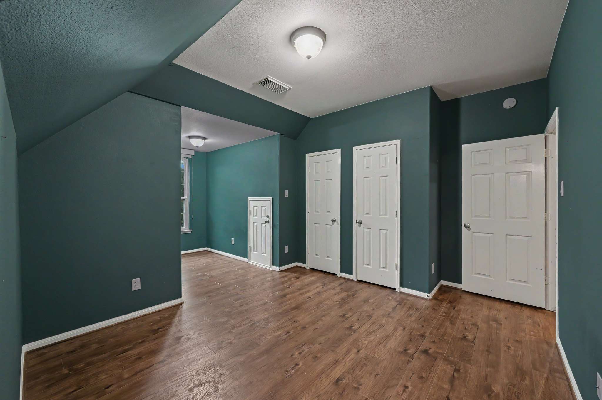 49 of 71. Spacious room with unique angles, featuring durable floors and ample storage options throughout.