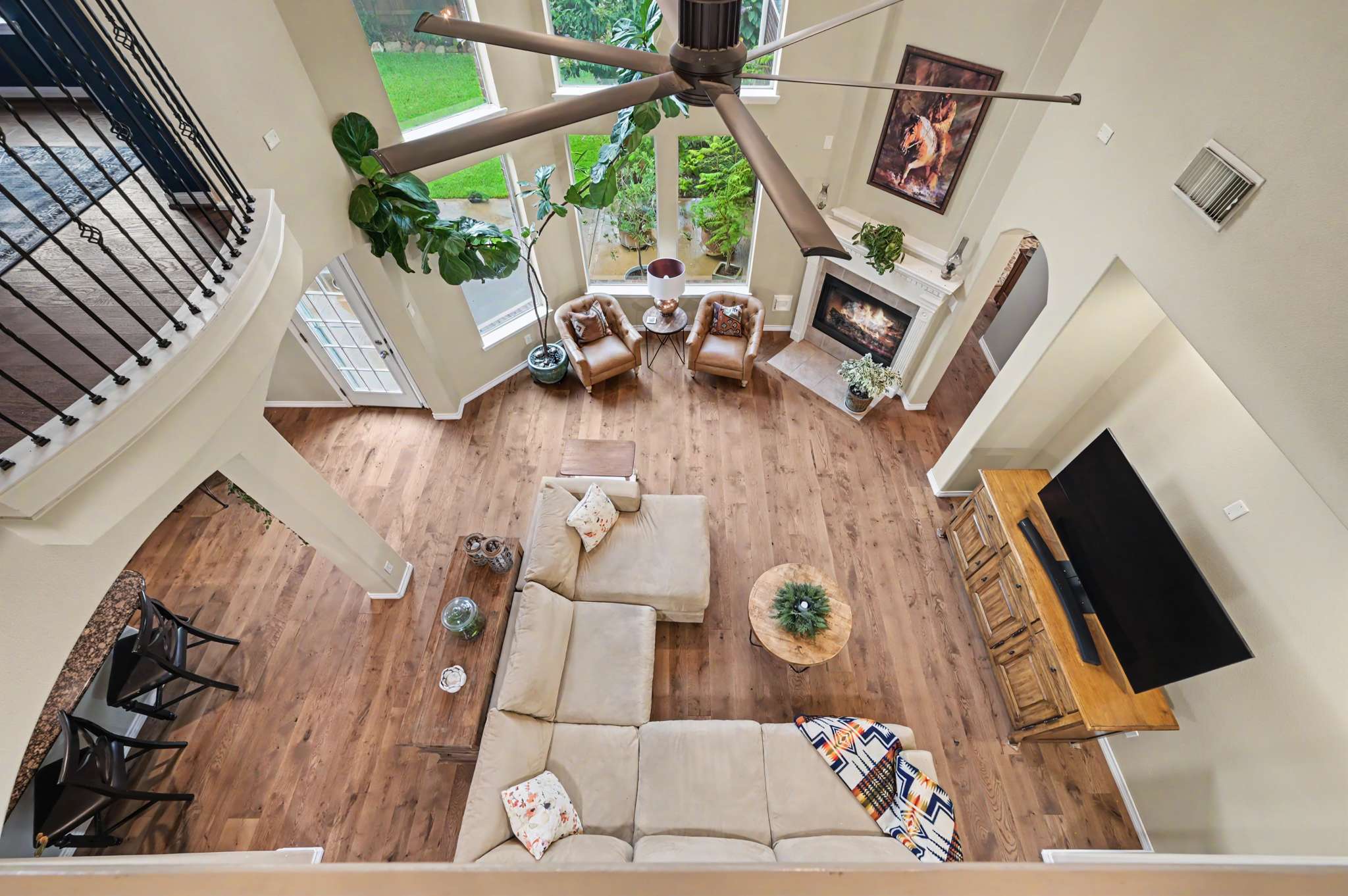 54 of 71. This spacious living area features high ceilings, abundant natural light, and a cozy fireplace for relaxation.