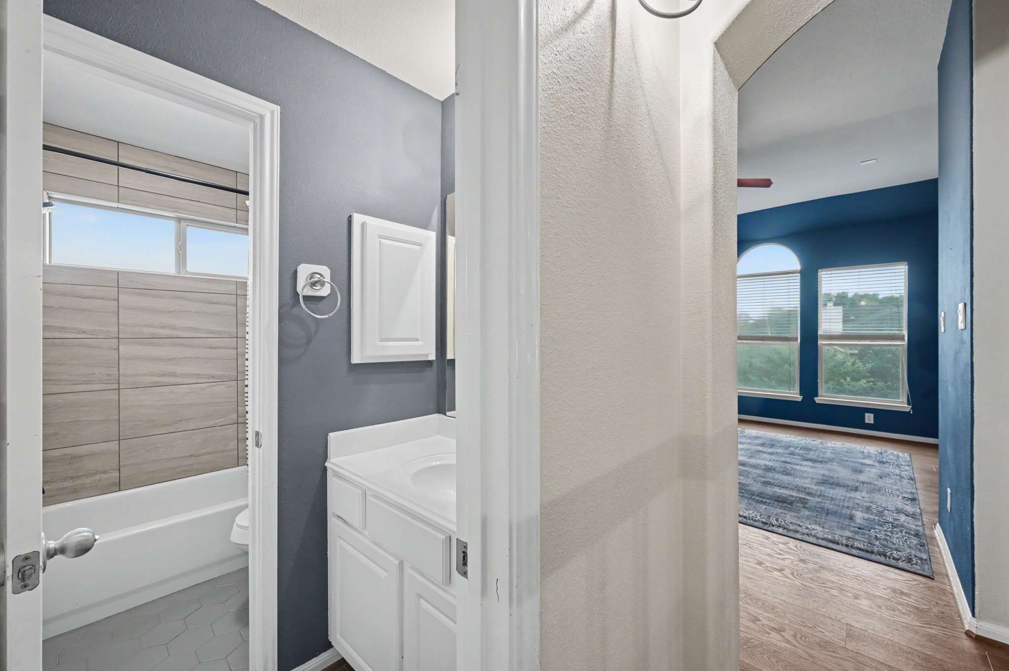 55 of 71. Bright and airy bathroom leads to a spacious living area with abundant natural light and scenic views.