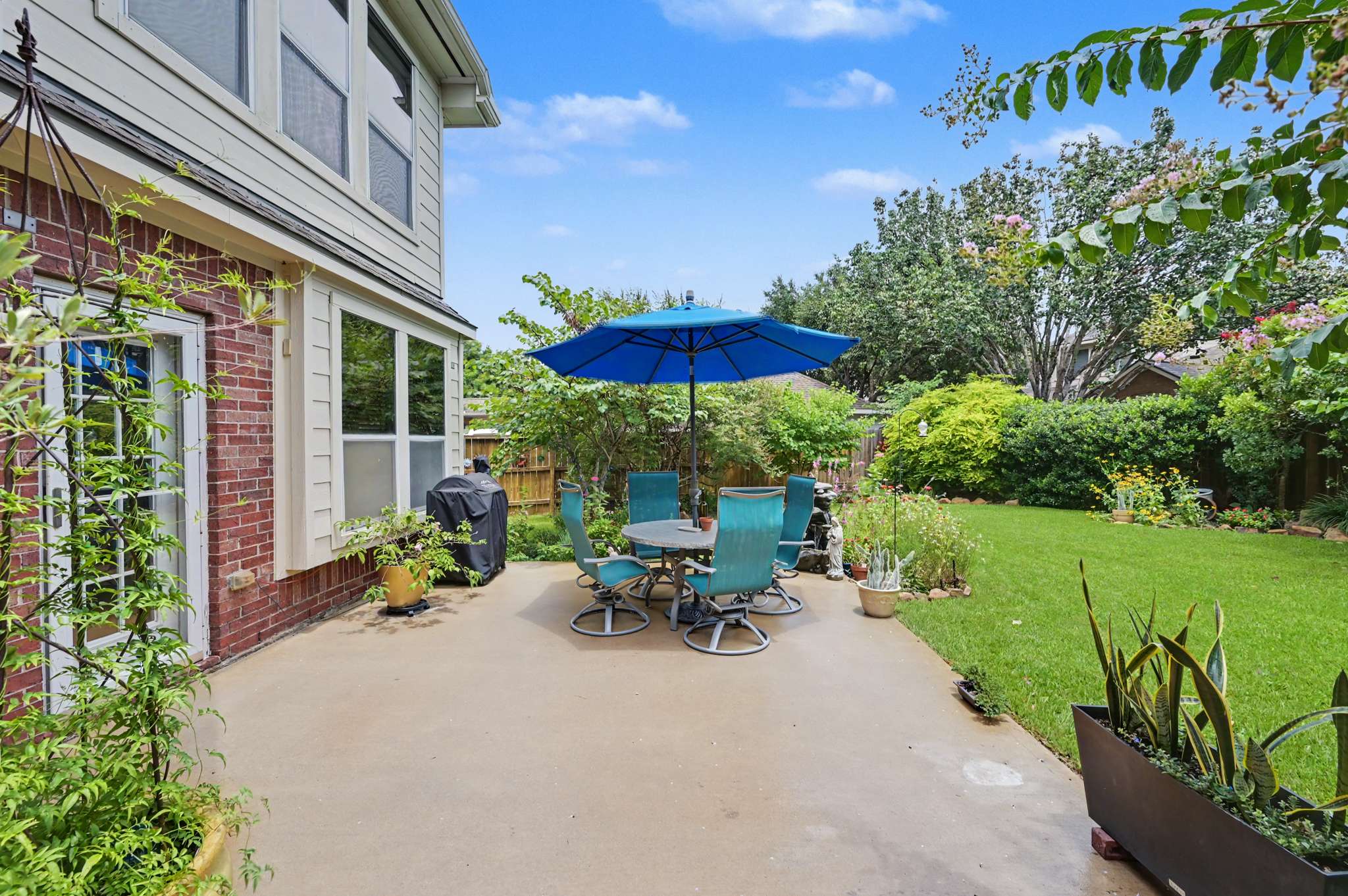 61 of 71. Discover a spacious patio with vibrant landscaping, perfect for outdoor gatherings and relaxation.