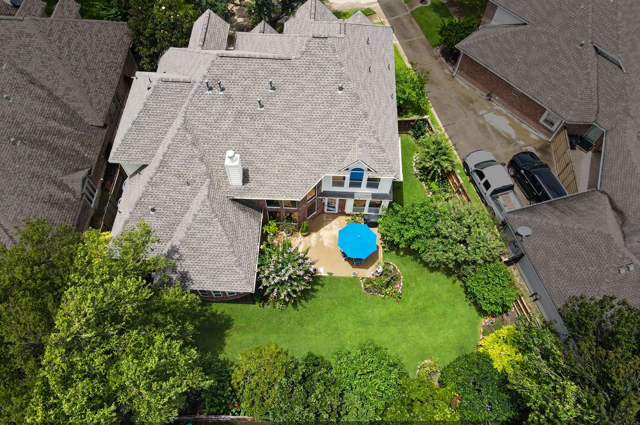 64 of 71. Spacious backyard oasis featuring a vibrant garden and inviting patio, perfect for outdoor gatherings and relaxation.