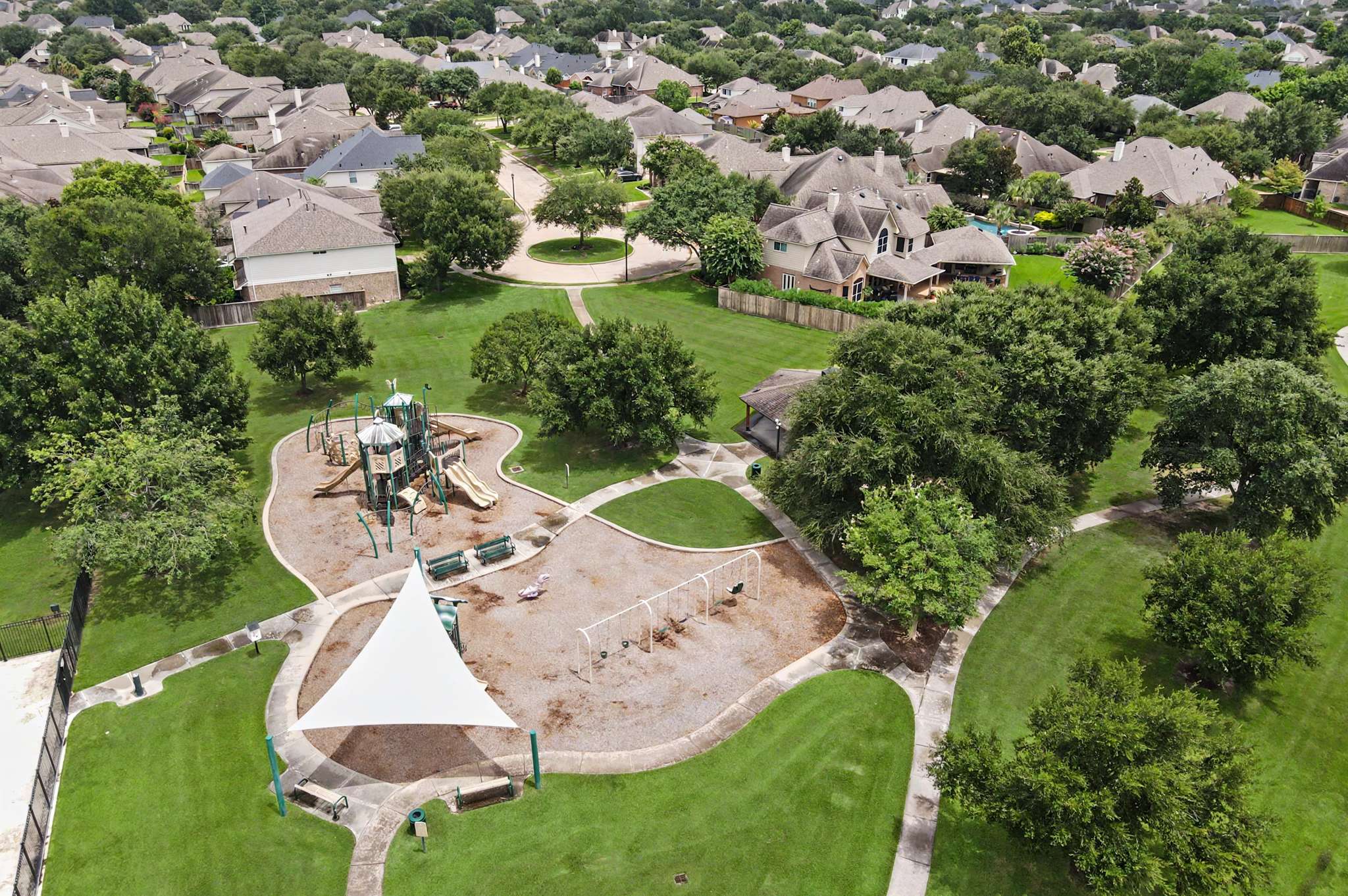 70 of 71. Spacious neighborhood park with playground, walking paths, and ample green space, perfect for family activities.
