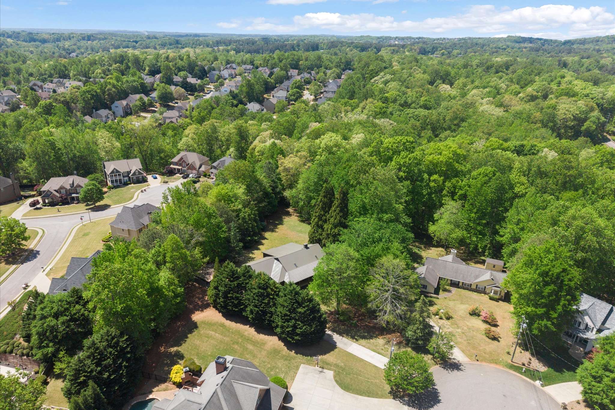 59 of 72. Stunning aerial view showcasing a lush, green neighborhood with spacious homes and tree-lined streets.