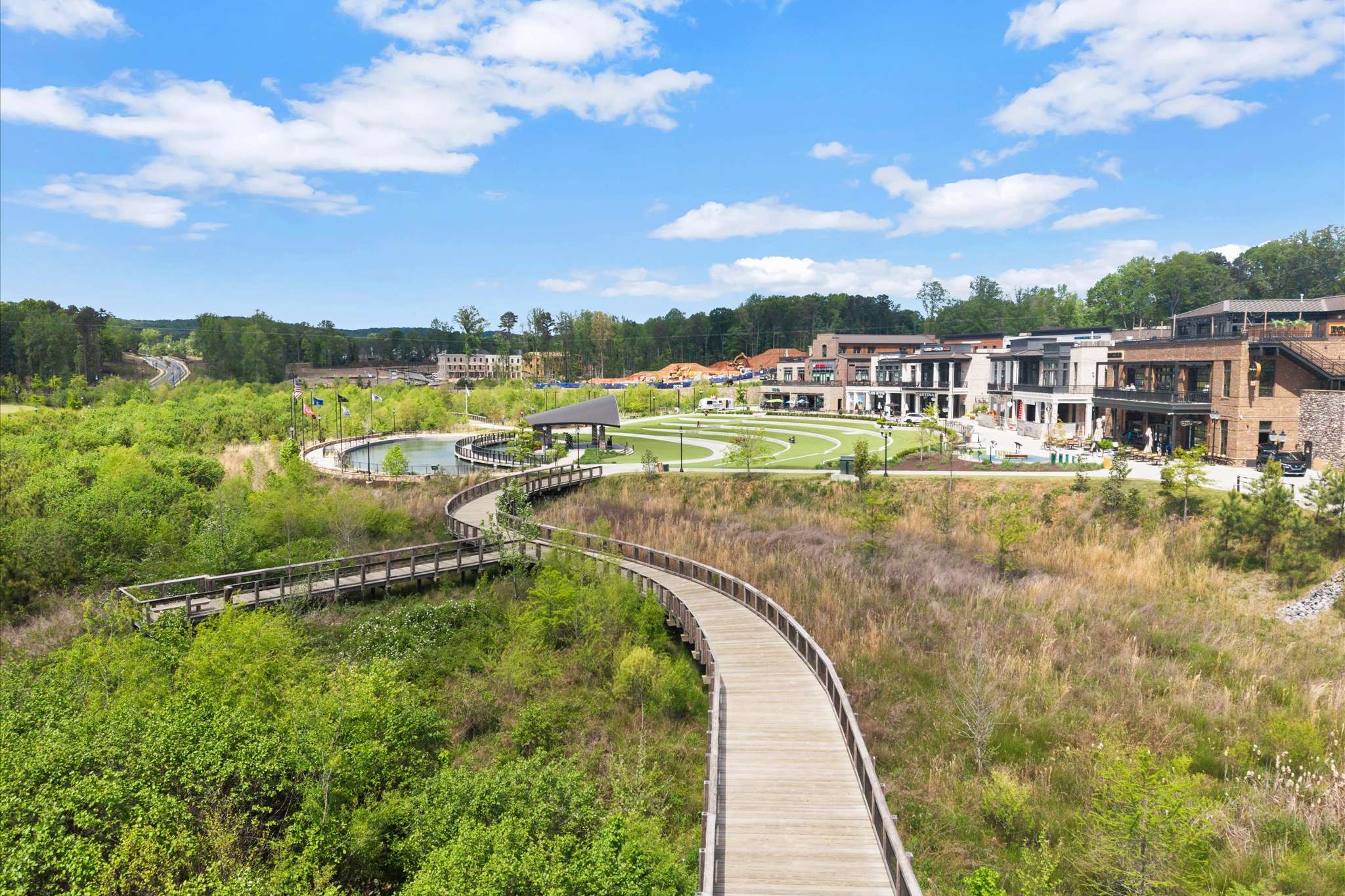 71 of 72. Scenic boardwalks weave through vibrant green spaces, leading to diverse shops and community areas.