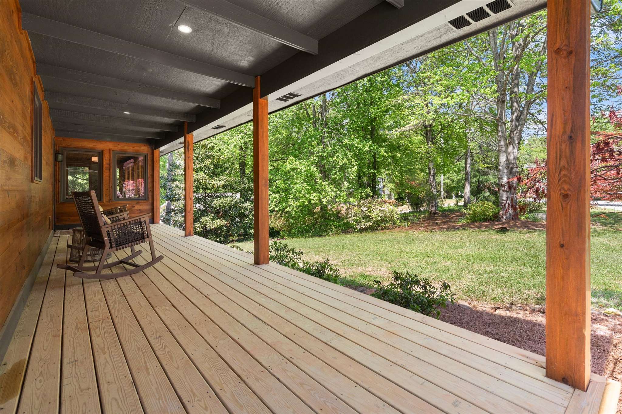11 of 72. Relax on the spacious porch overlooking a lush landscape, perfect for enjoying nature's beauty.