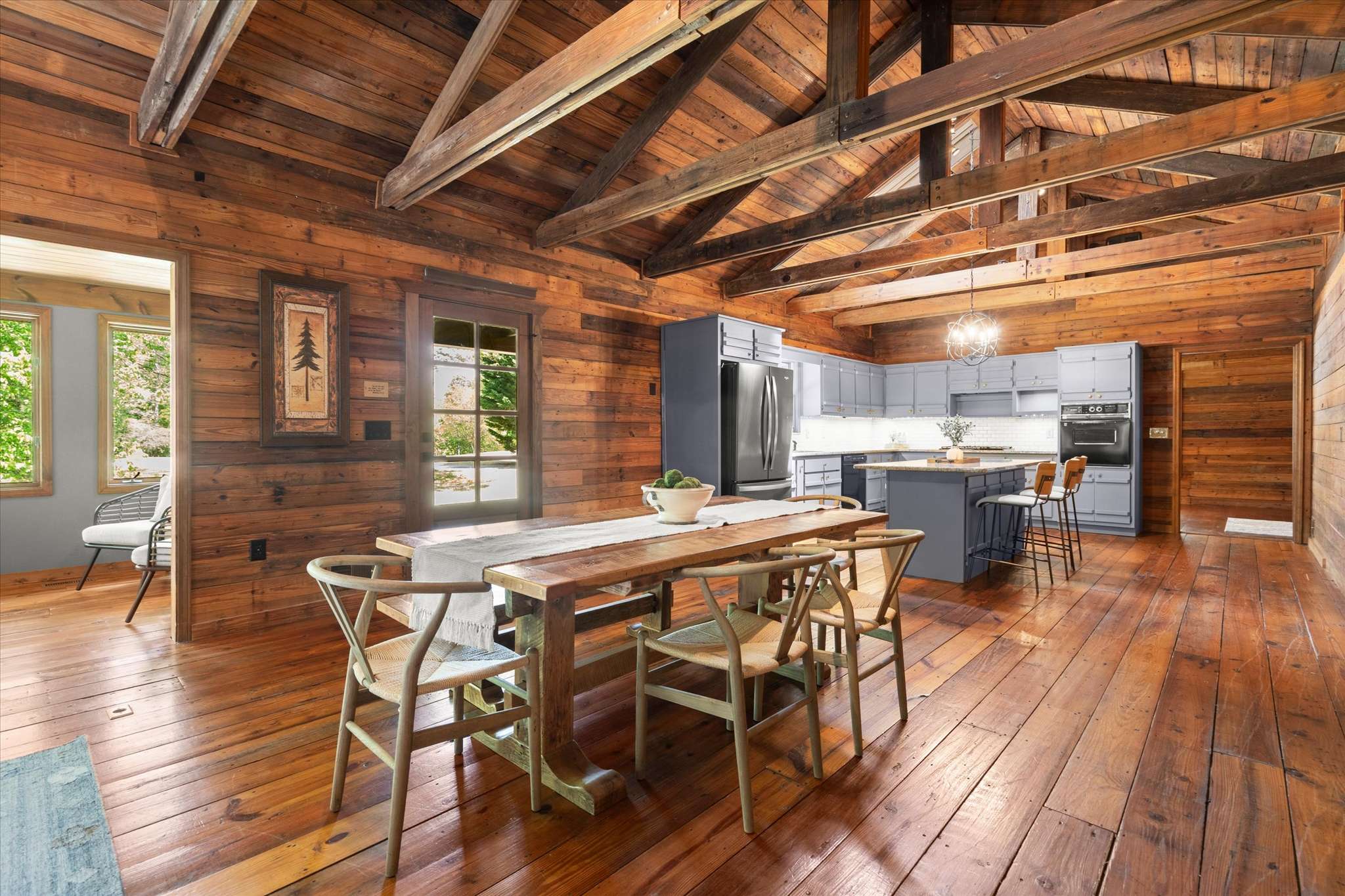 15 of 72. Bright, open kitchen and dining area feature rustic wood finishes, seamlessly blending modern amenities with cozy design.