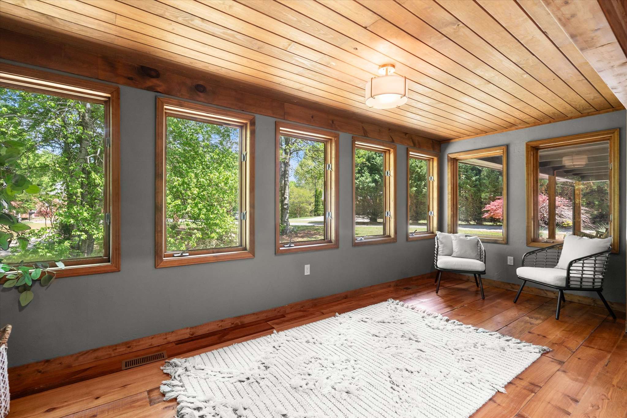 18 of 72. Bright and airy sunroom featuring expansive windows and natural wood accents, perfect for relaxation or cozy gatherings.