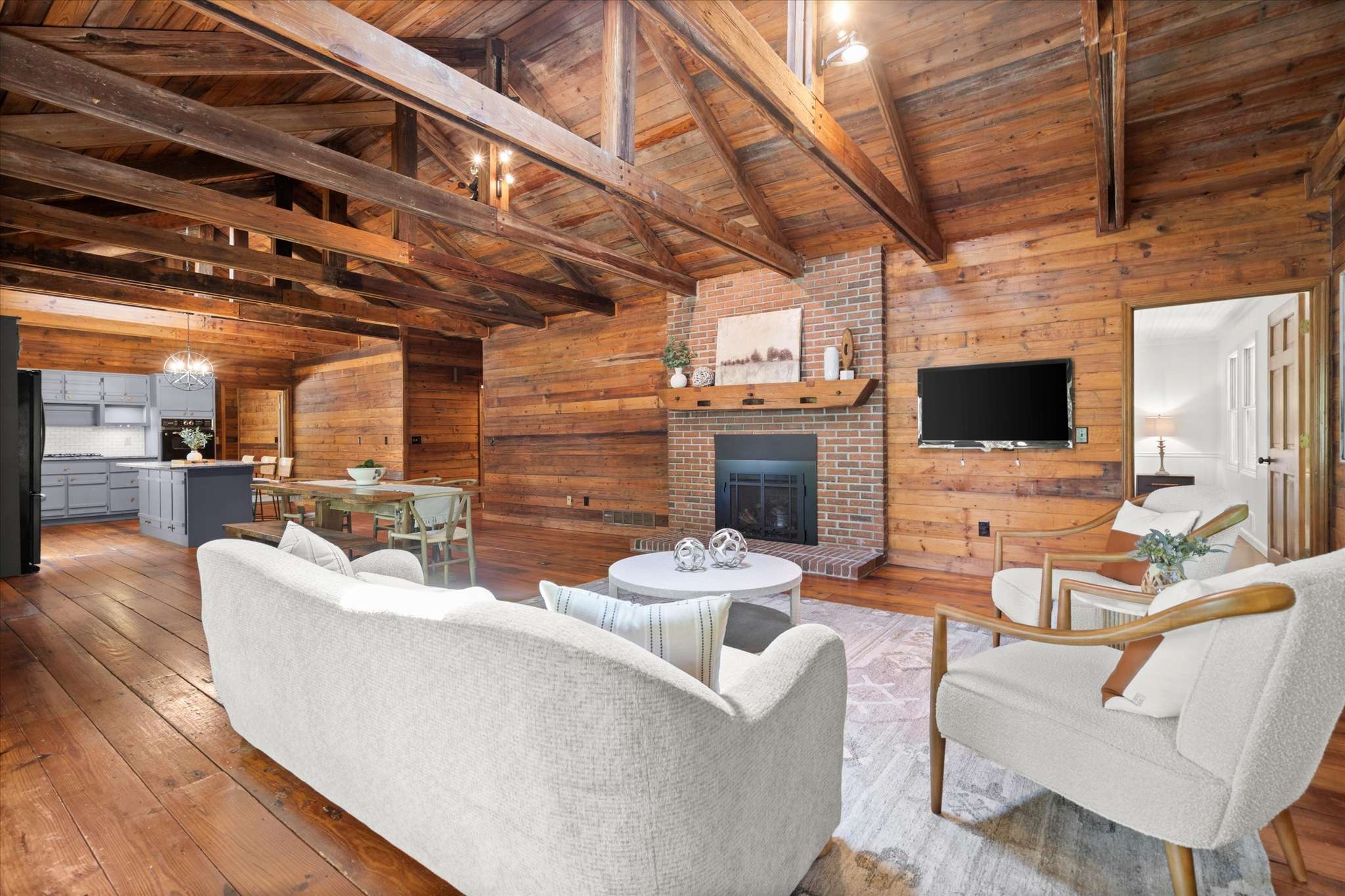 19 of 72. Spacious open-concept living area with exposed beams, fireplace, and a seamless flow into the kitchen.