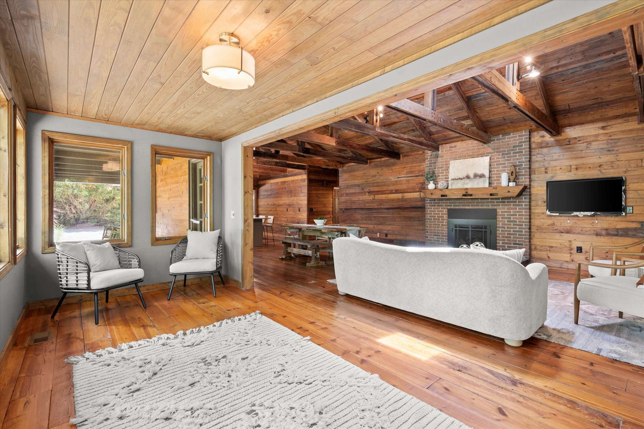 20 of 72. Spacious living area features exposed wood beams, natural lighting, and a cozy fireplace for relaxation.