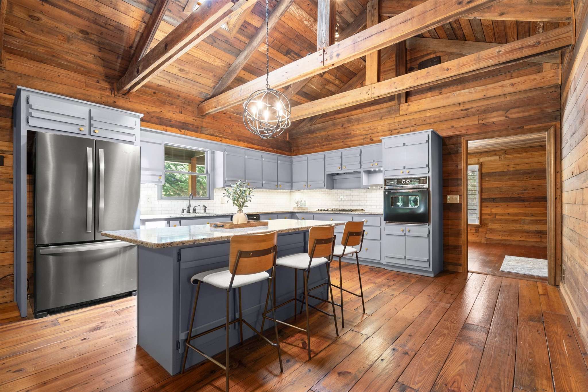 2 of 72. Spacious kitchen featuring modern appliances, ample storage, and stunning wood accents for a welcoming atmosphere.