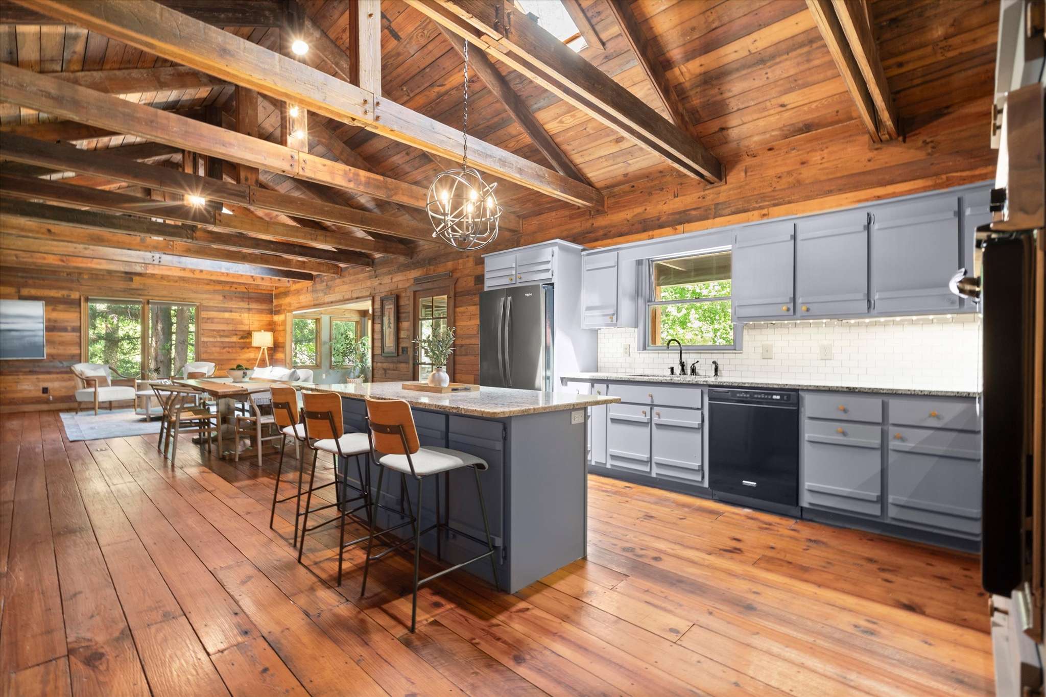 24 of 72. Experience a warm, open kitchen and dining area with natural light and rustic wooden beams throughout.