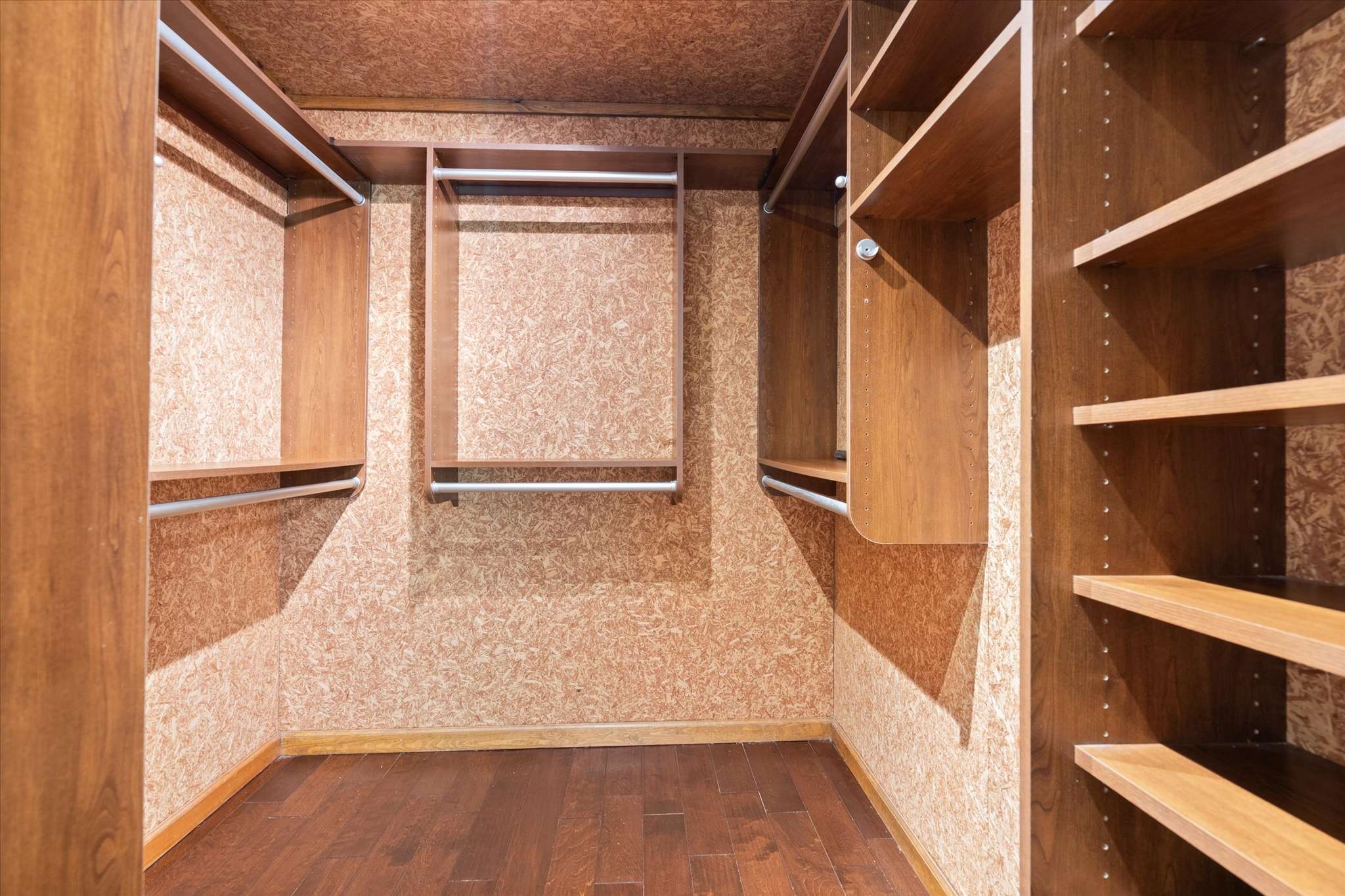36 of 72. Spacious walk-in closet featuring rich wood finishes and ample shelving for organized storage solutions.