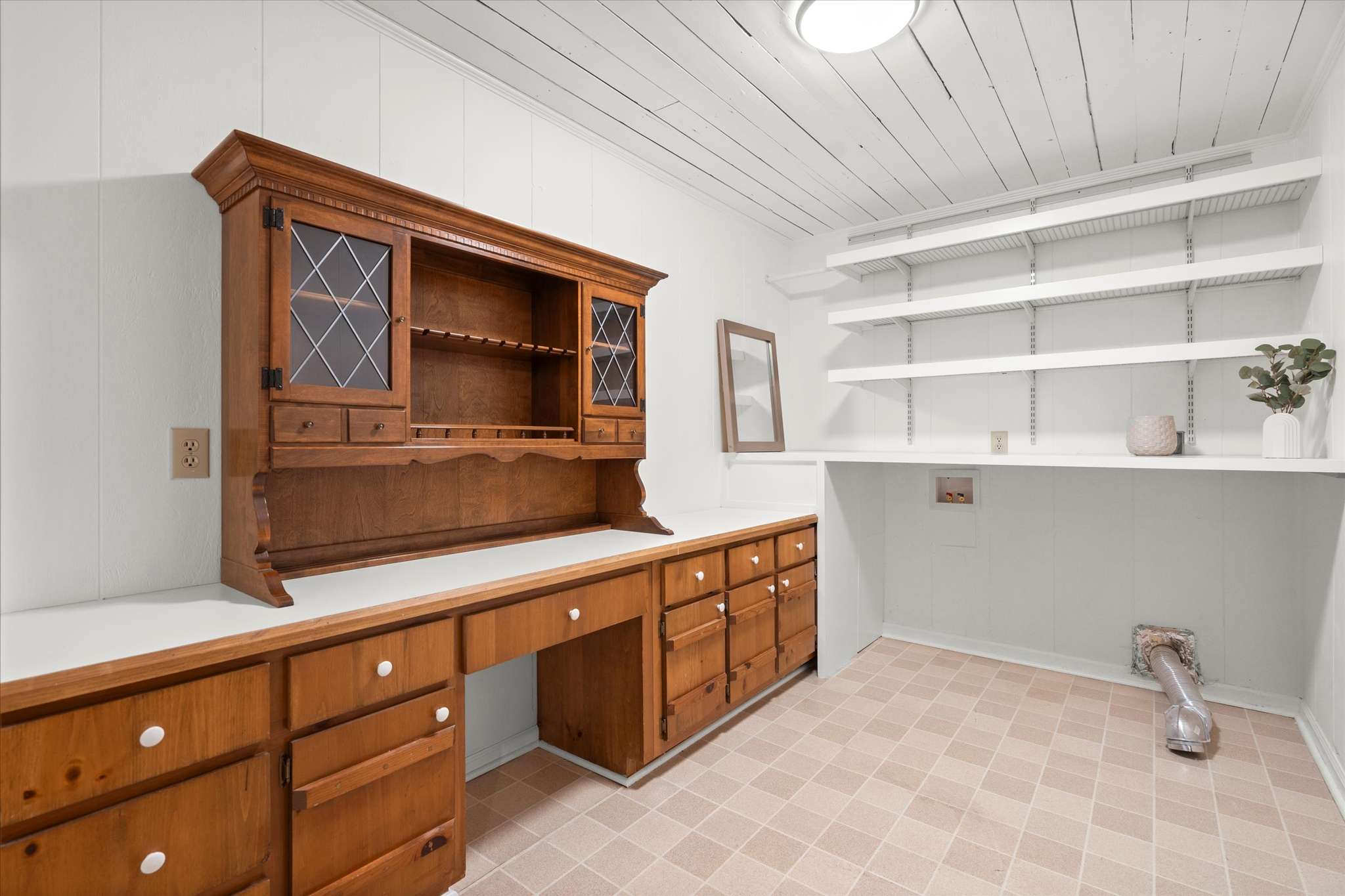 37 of 72. Spacious work area featuring built-in cabinetry and shelving, ideal for crafting or organization.