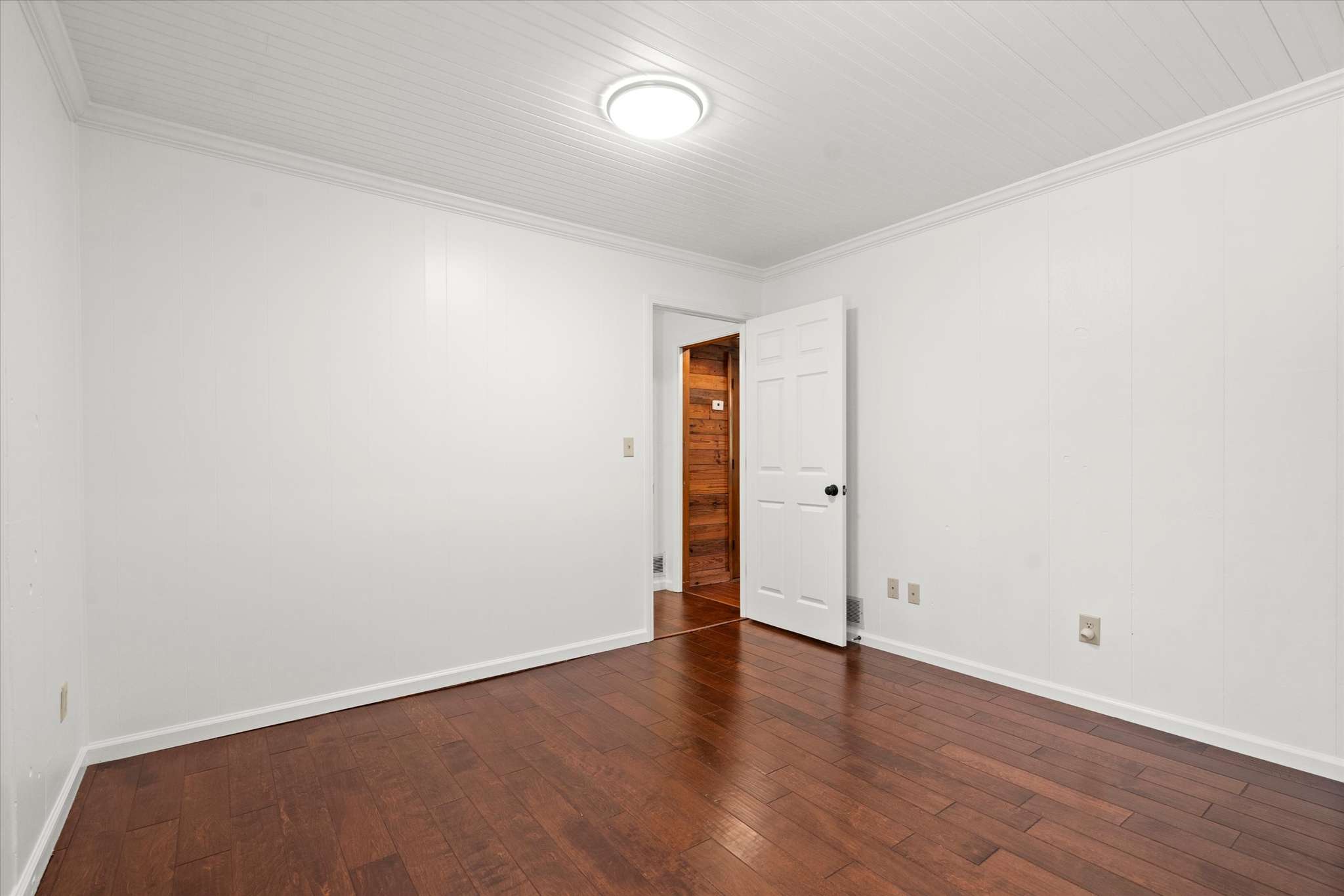 40 of 72. Bright, versatile room with hardwood flooring and direct access to adjoining spaces, perfect for various uses.