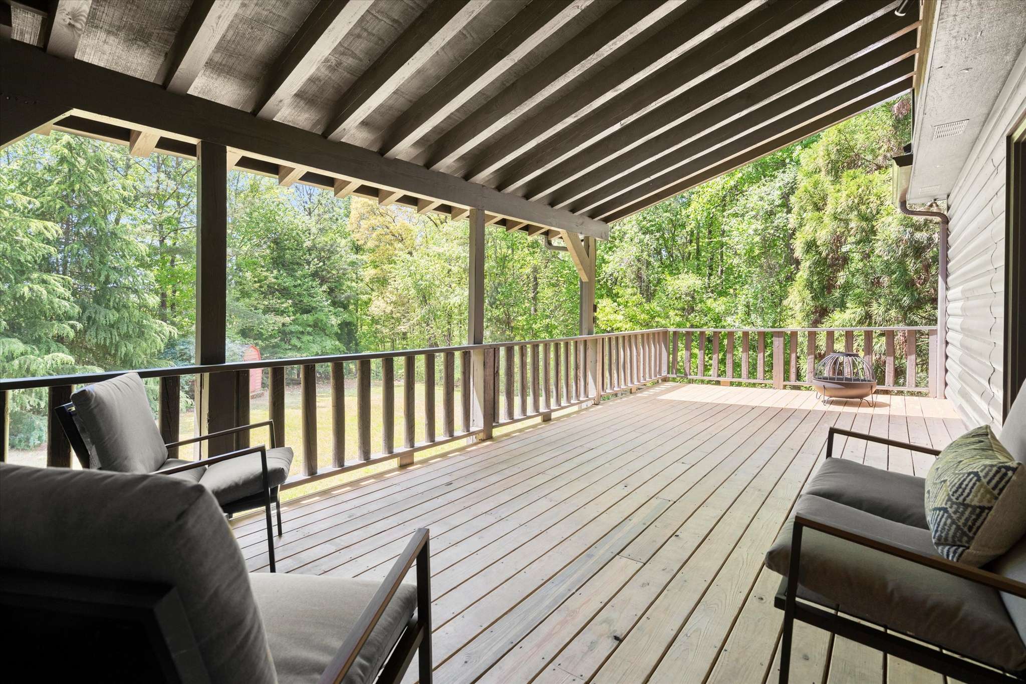 45 of 72. Spacious deck surrounded by lush greenery, perfect for outdoor gatherings and relaxation in nature.