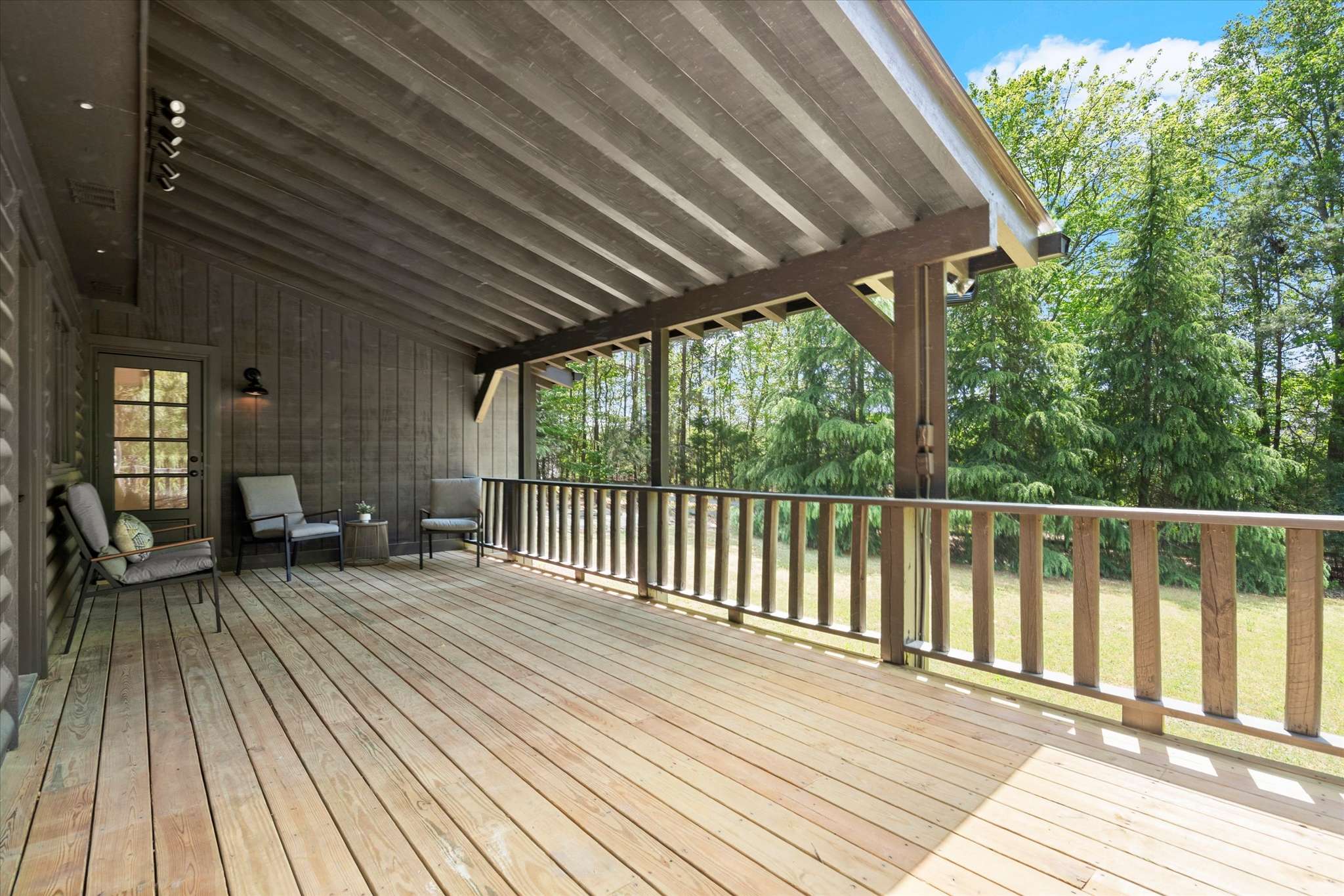 47 of 72. Relax on the expansive covered deck, surrounded by lush greenery and serene natural views.