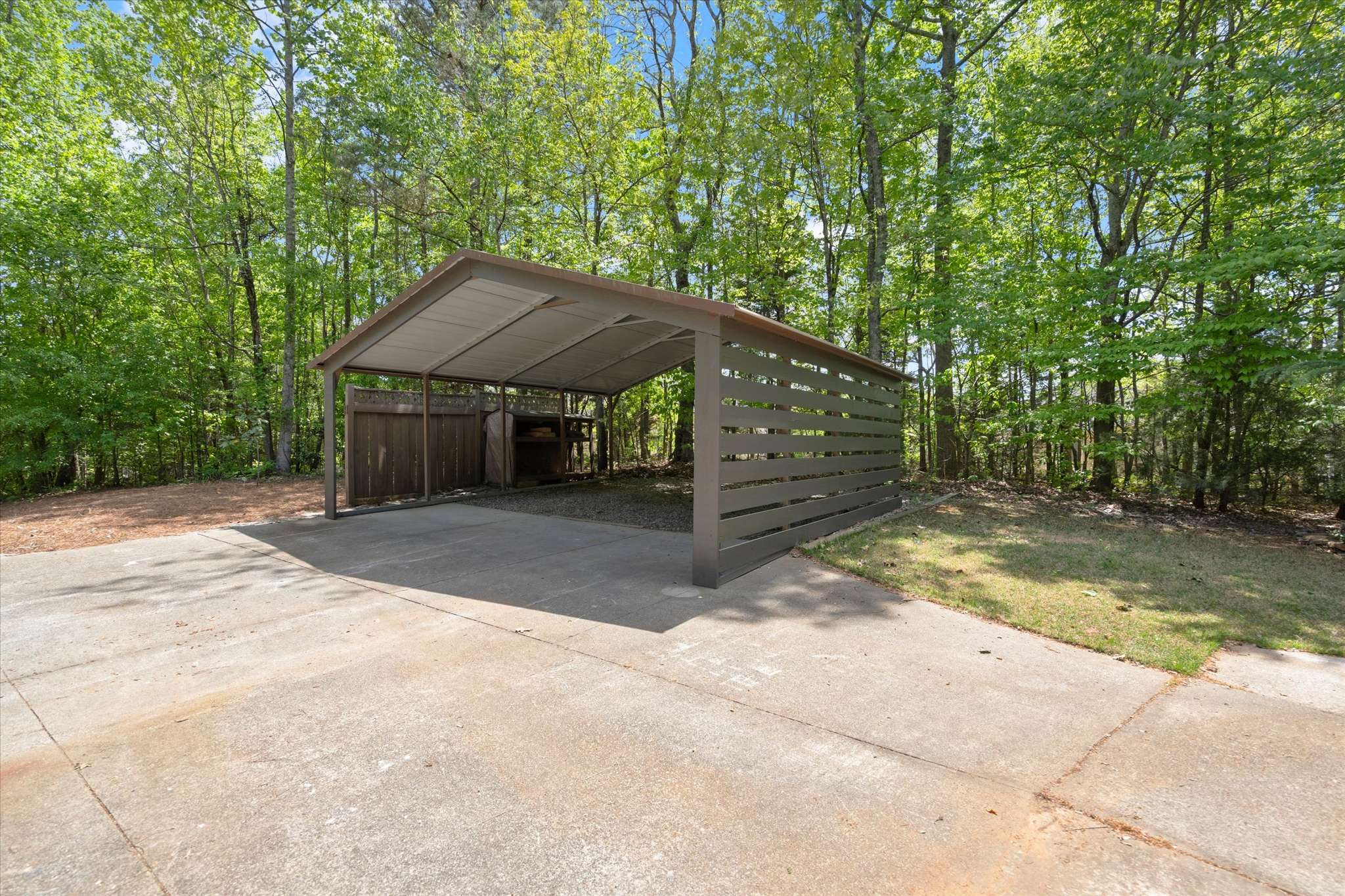 48 of 72. This spacious carport offers convenient coverage and easy access in a tranquil wooded setting.