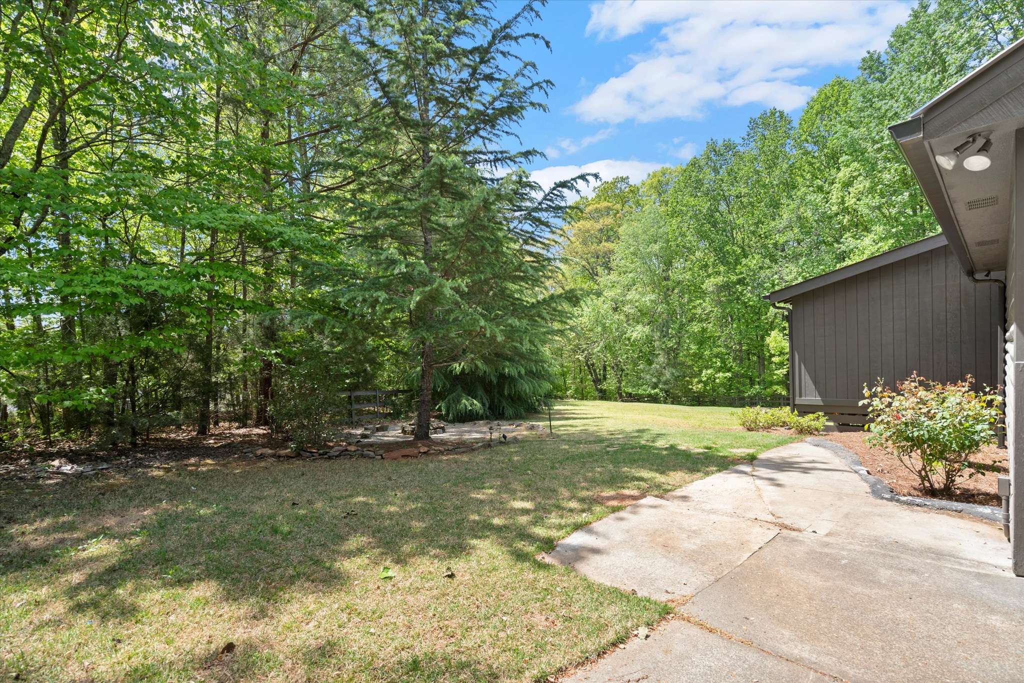 49 of 72. Spacious outdoor area surrounded by lush greenery, perfect for relaxation or entertaining family and friends.