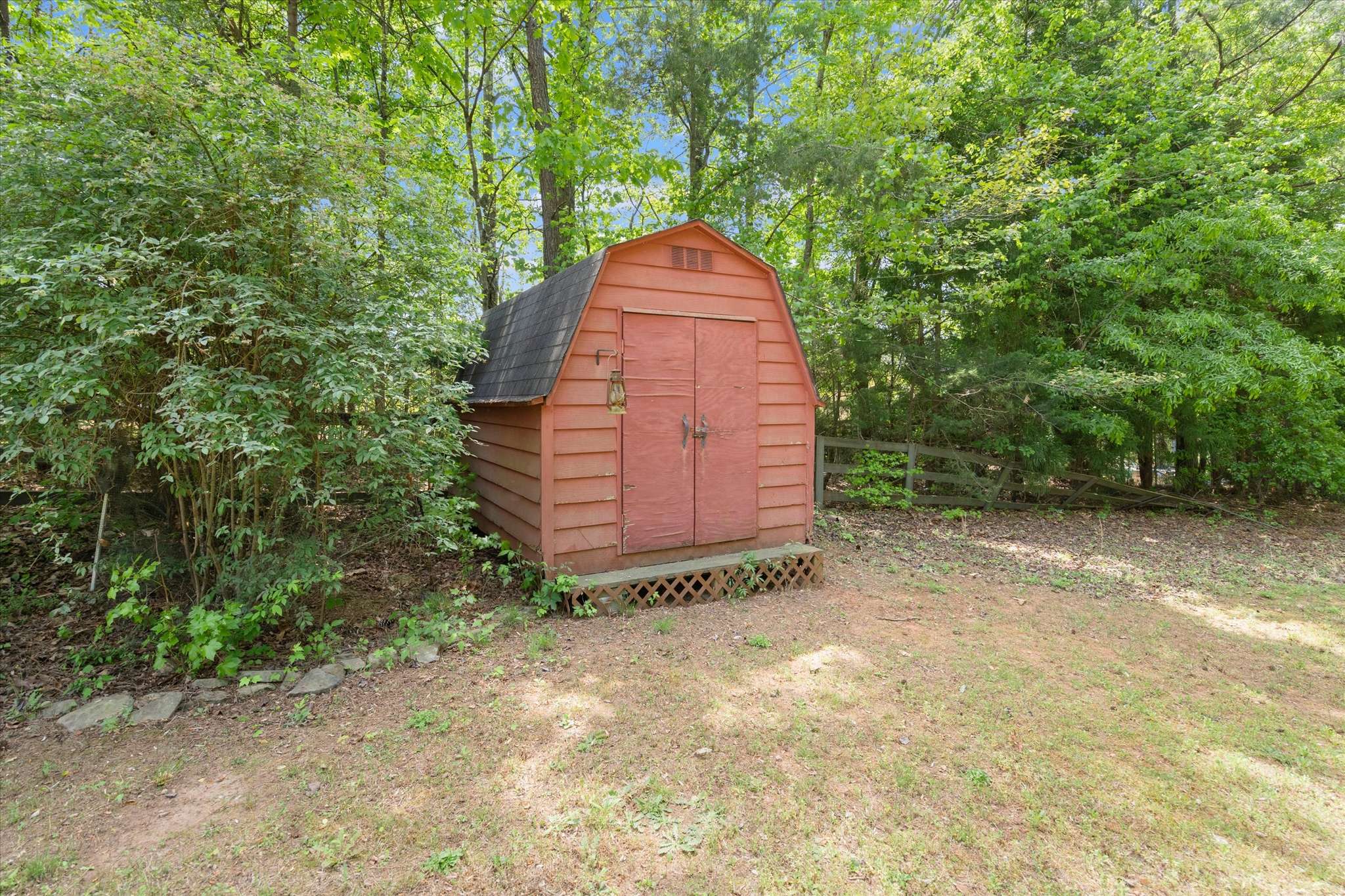 54 of 72. A unique backyard shed nestled among lush greenery, perfect for storage or creative projects.