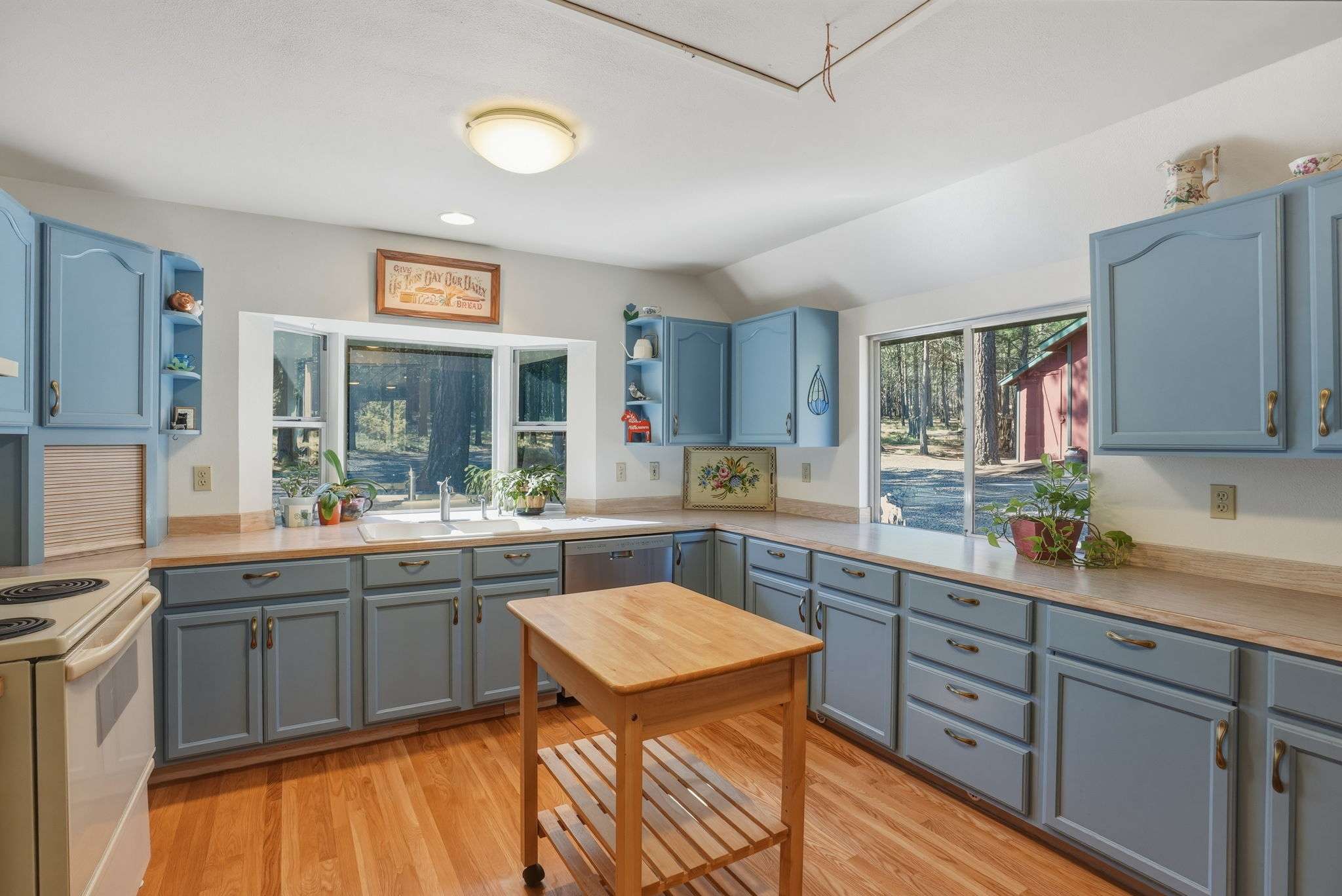 20 of 61. Bright and spacious kitchen featuring custom cabinetry, ample countertop space, and large windows overlooking the yard.