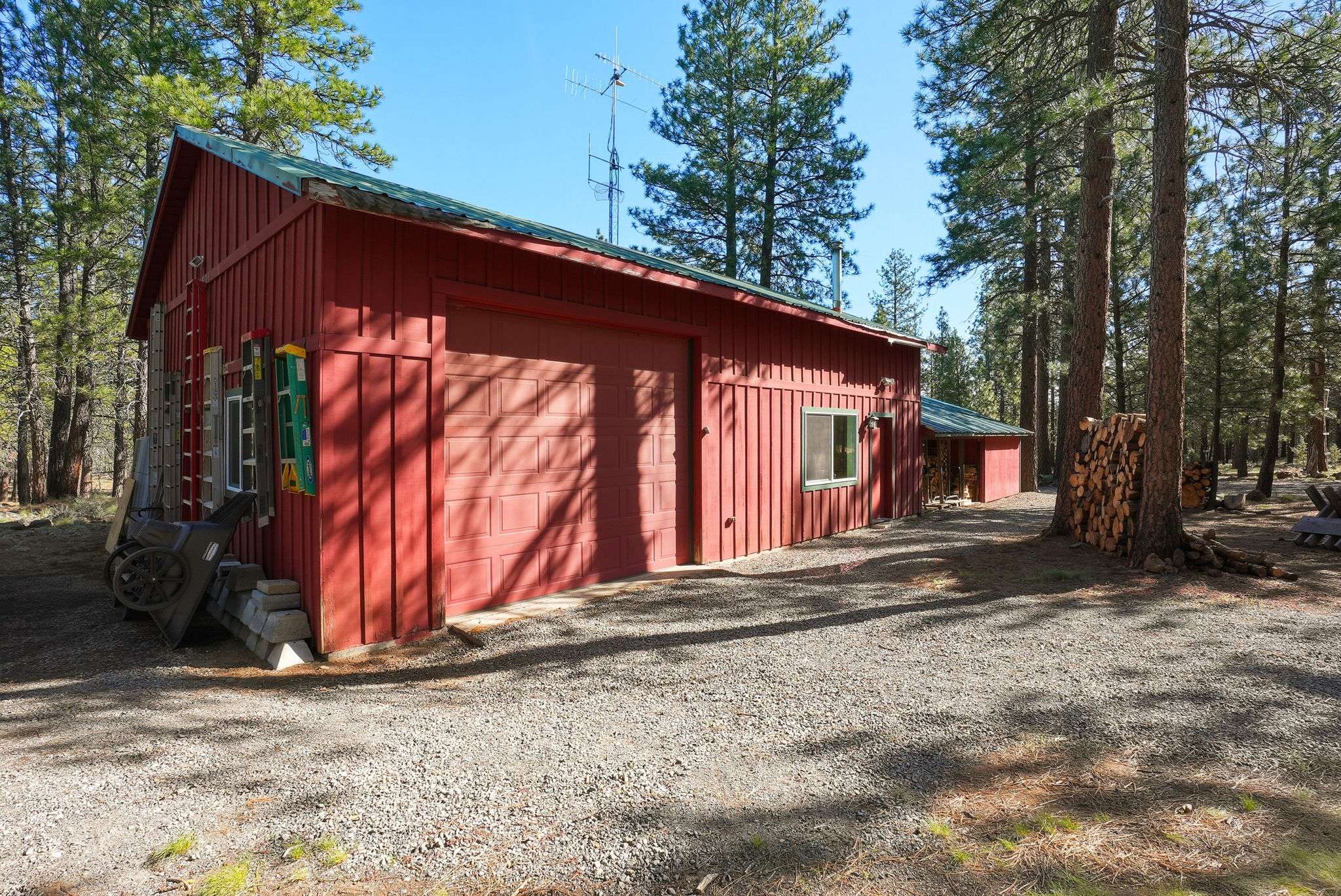 42 of 61. 30'x40' shop with a 30'x16.5' RV bay and two additional 22'x14' rooms. The 2-car oversized garage has an insulated storage area with baseboard heat. Outside is a 12'x6' shed and a 16'x6' covered wood storage area. The detached pump house/greenhouse is 12'x8'.