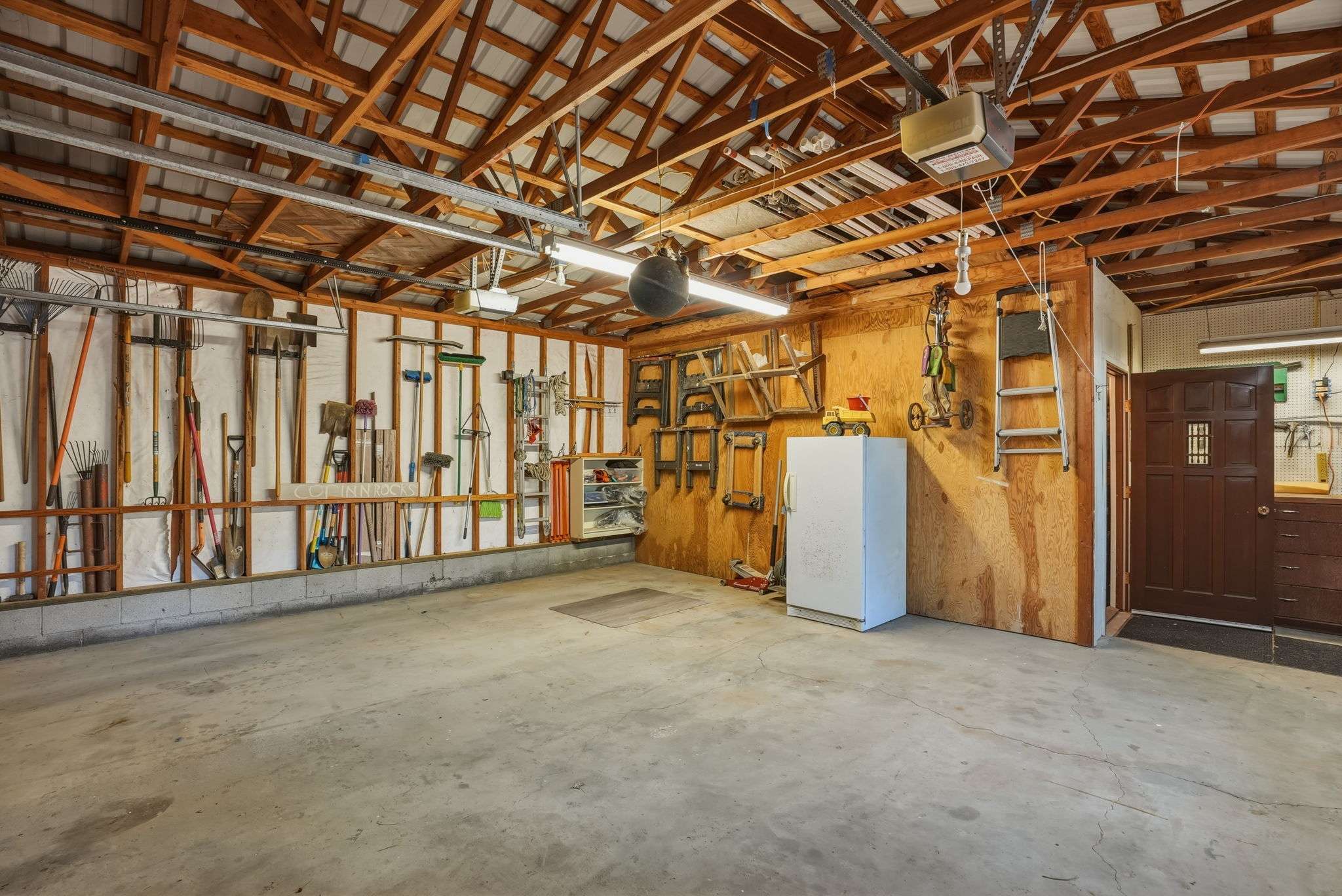 48 of 61. The 2-car oversized garage has heated storage, dedicated wood storage, and a storage room. Plus exterior shed and wood storage.