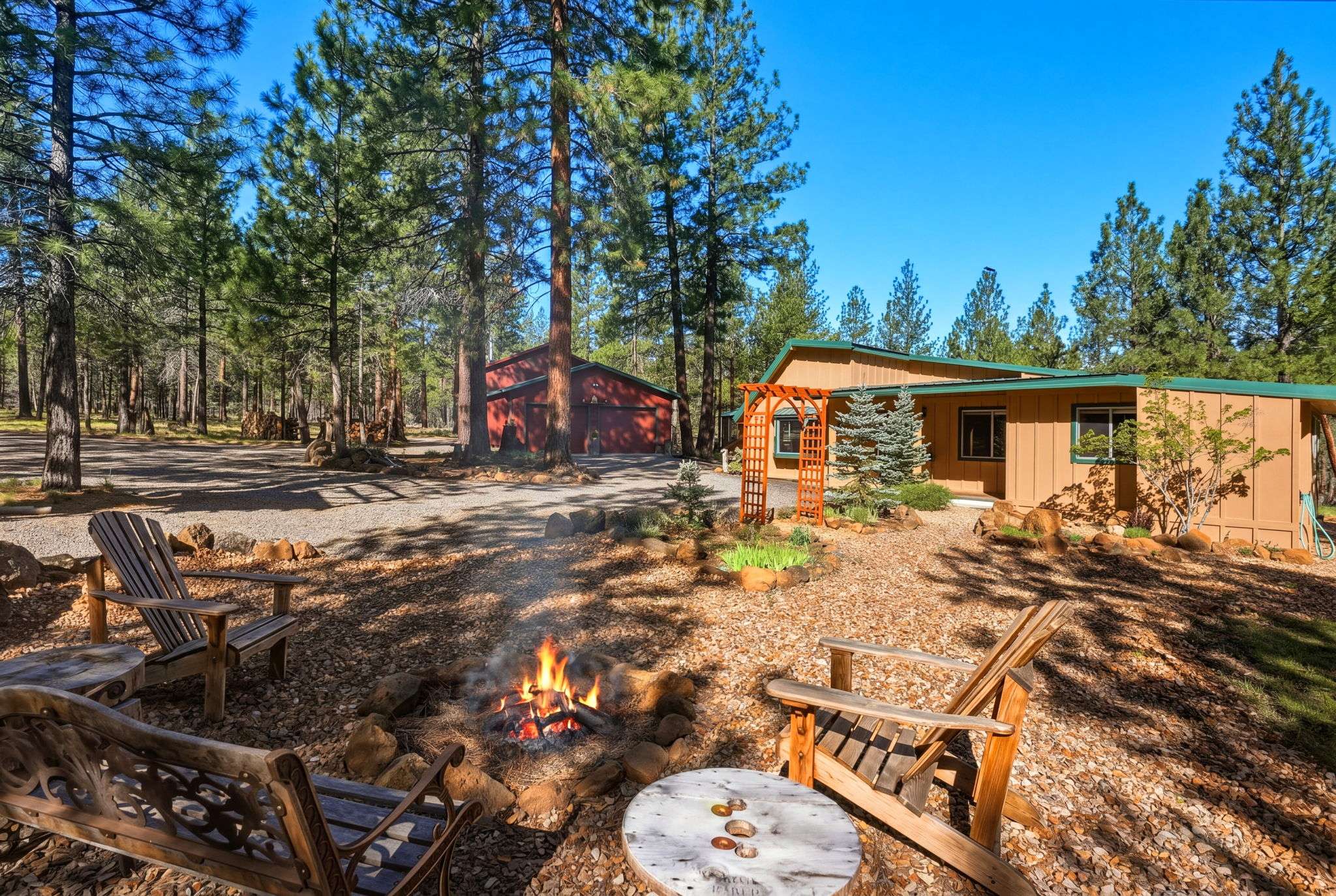 4 of 61. This peaceful retreat features outdoor seating around a cozy fire pit, surrounded by towering pines and a spacious yard.