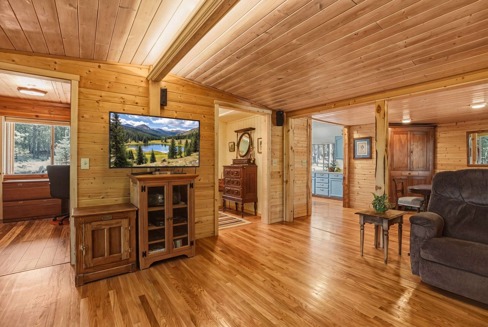 22 of 61. Cozy living area features natural wood finishes and ample sunlight, creating a warm, inviting atmosphere.