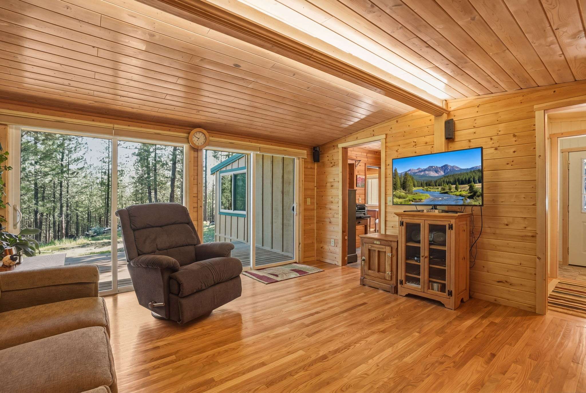 9 of 61. Welcome to a cozy retreat featuring natural wood finishes and two sliders for abundant light.
