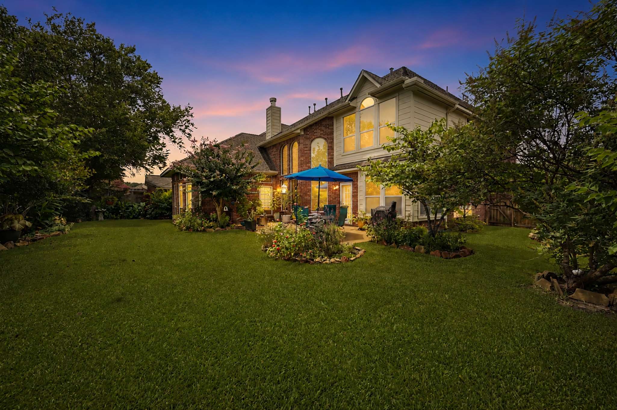 12 of 71. Spacious backyard oasis featuring lush landscaping and inviting outdoor seating, perfect for gatherings and relaxation.
