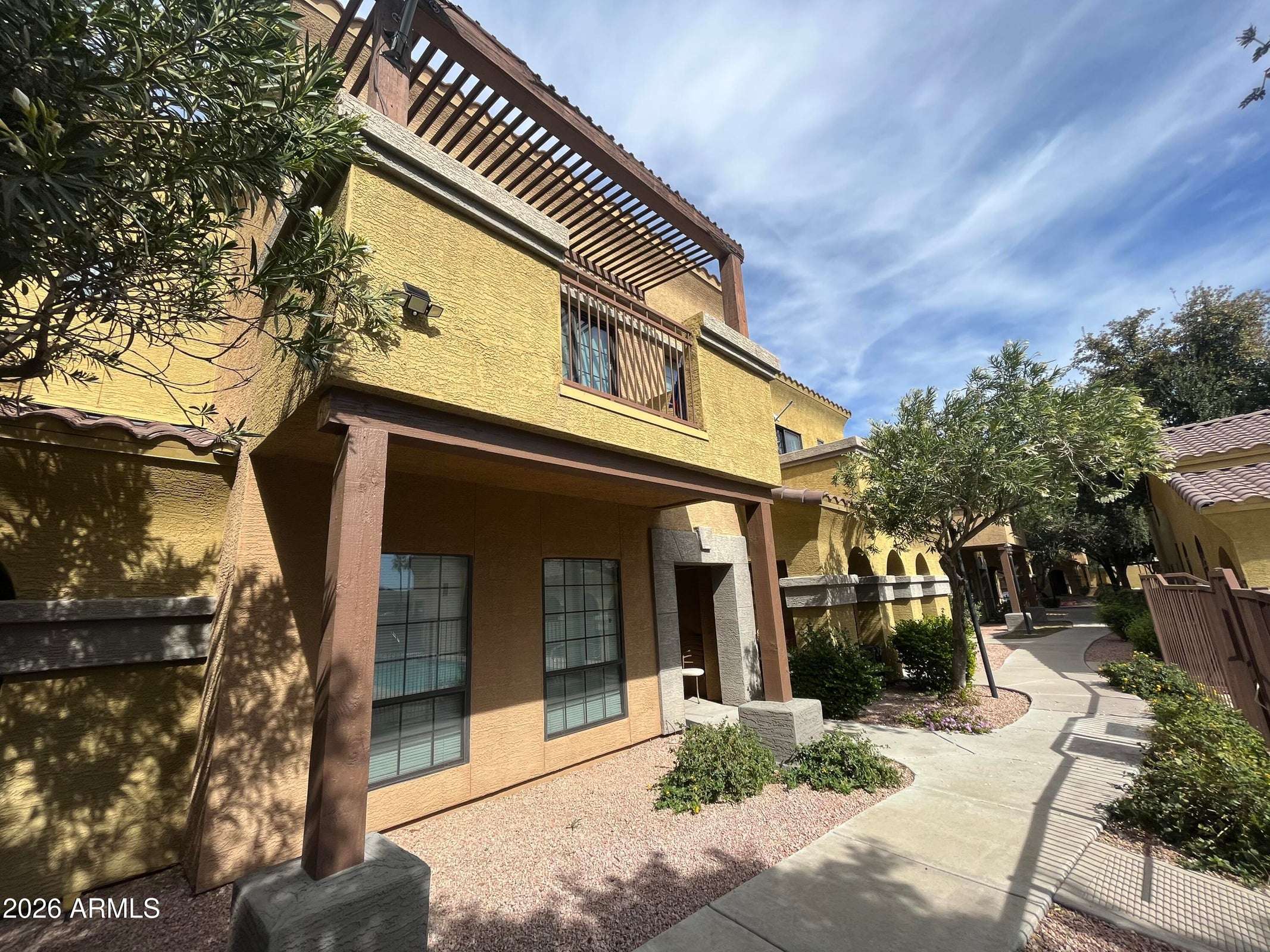 1 of 26. Beautiful former model townhome with attractive architecture, mature landscaping, and a covered front entry located within the desirable gated Villa Milano community in Phoenix.