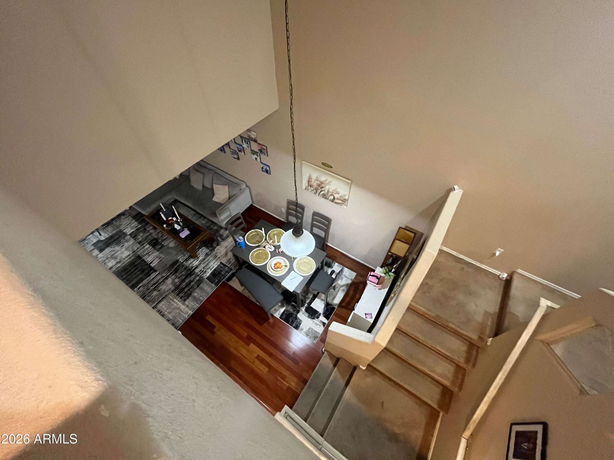 4 of 26. A bird's-eye perspective showcases the impressive vaulted ceilings, open dining area, wood flooring, and spacious living room designed for comfortable everyday living.