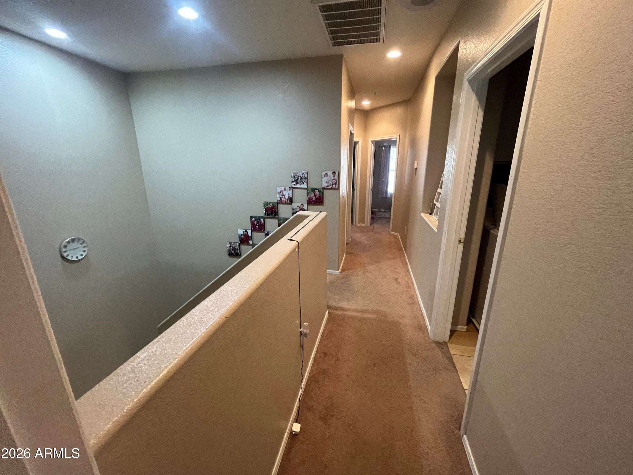 9 of 26. The upstairs landing overlooks the main living area and connects the secondary bedrooms, laundry room, and primary suite with an open, airy design.