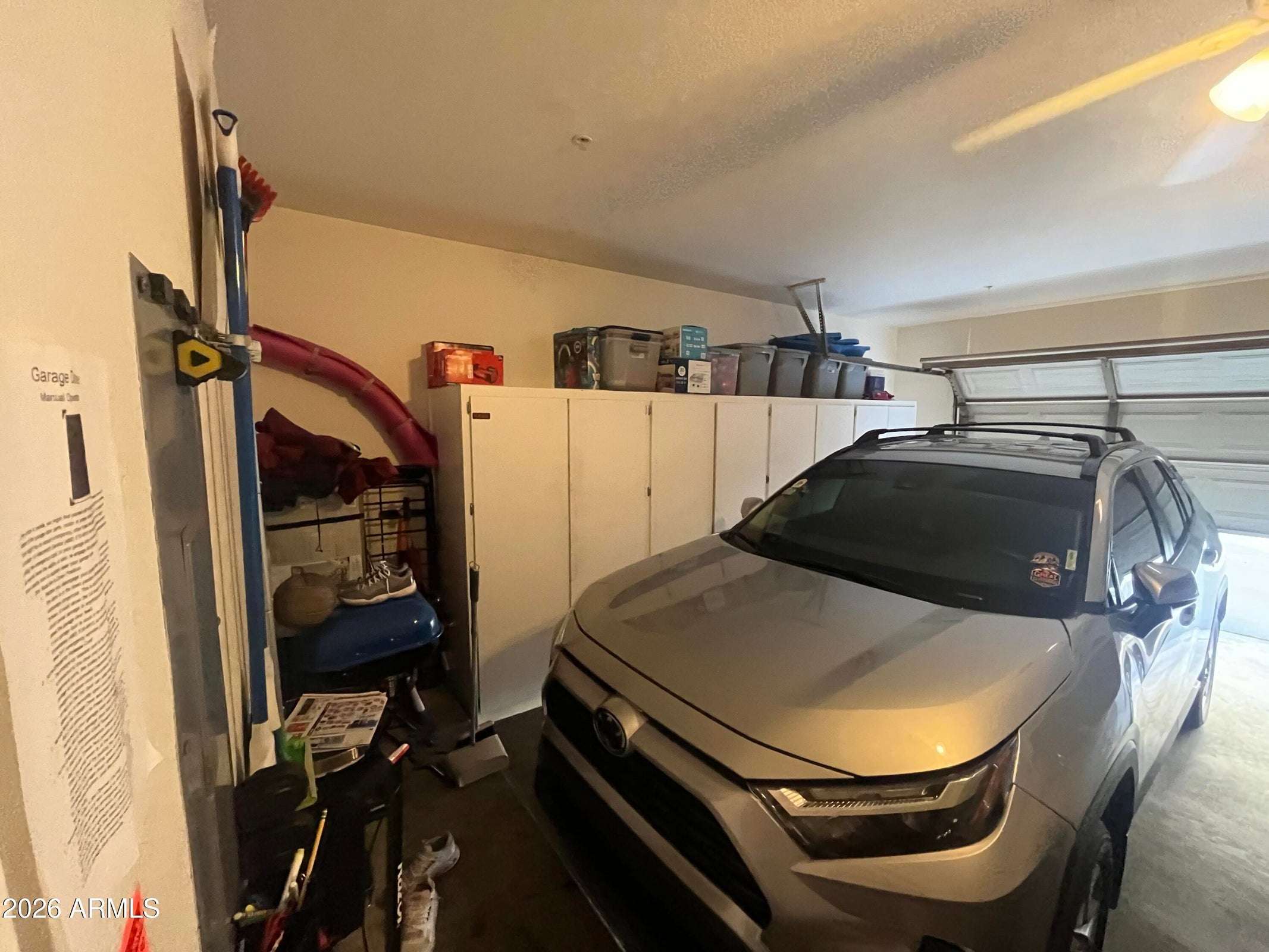11 of 26. An attached two-car garage offers built-in storage cabinets, rear vehicle entry, and ample space for parking, tools, and seasonal storage, adding everyday convenience to this Phoenix home.