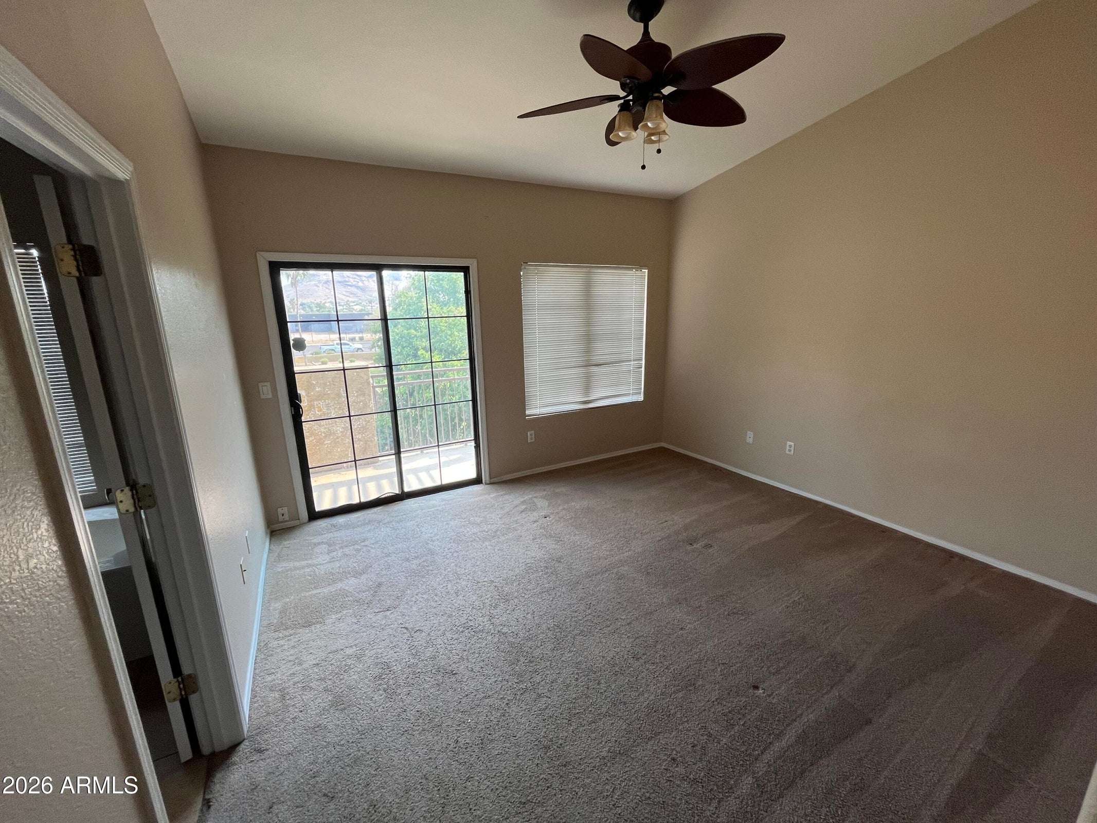 15 of 26. The spacious owner's suite offers vaulted ceilings, plush carpeting, abundant natural light, and direct access to the private balcony, creating a relaxing personal retreat.