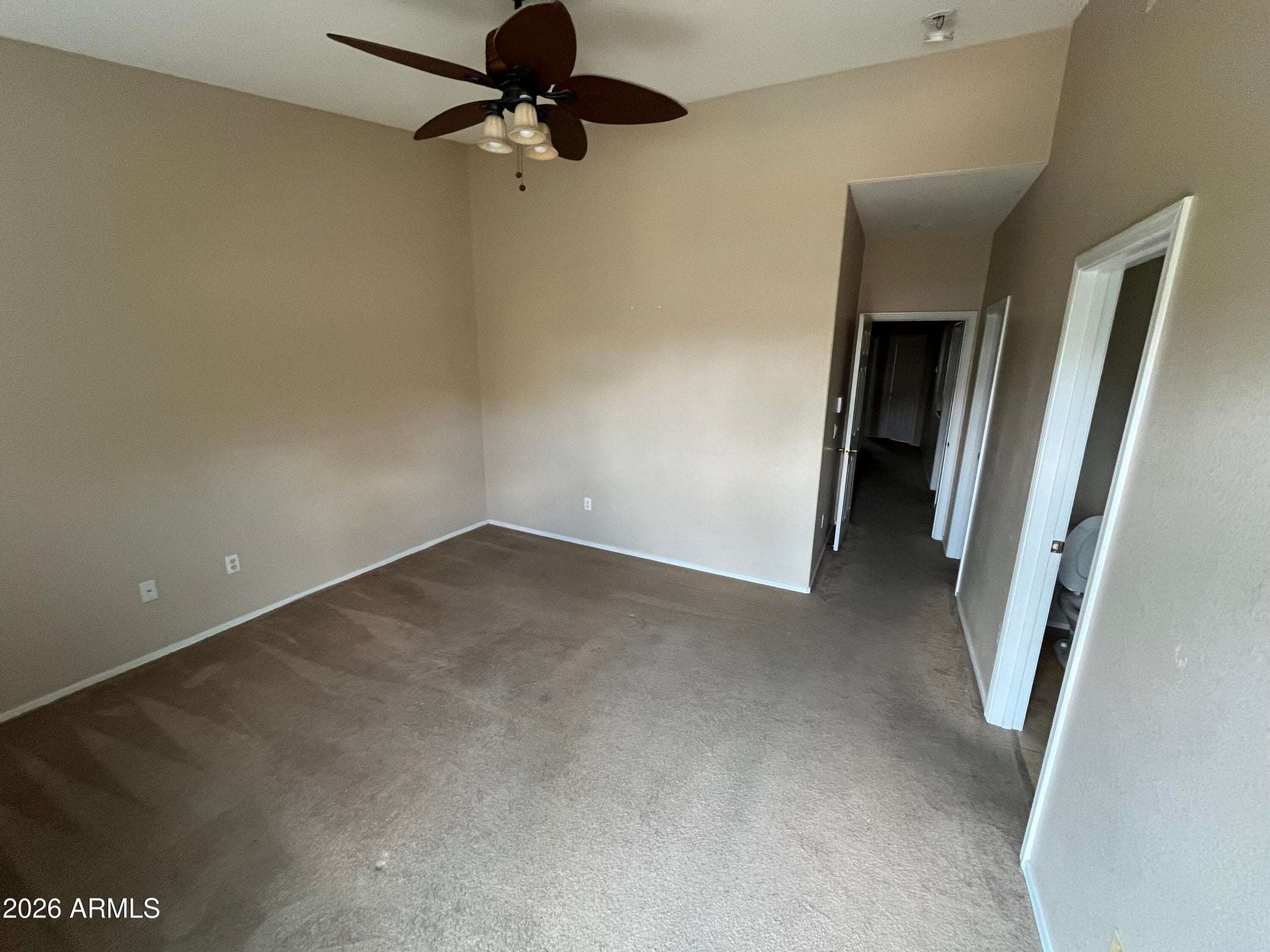 17 of 26. A spacious primary bedroom with vaulted ceilings, neutral finishes, and comfortable carpeting offers a versatile space ready for your personal style.