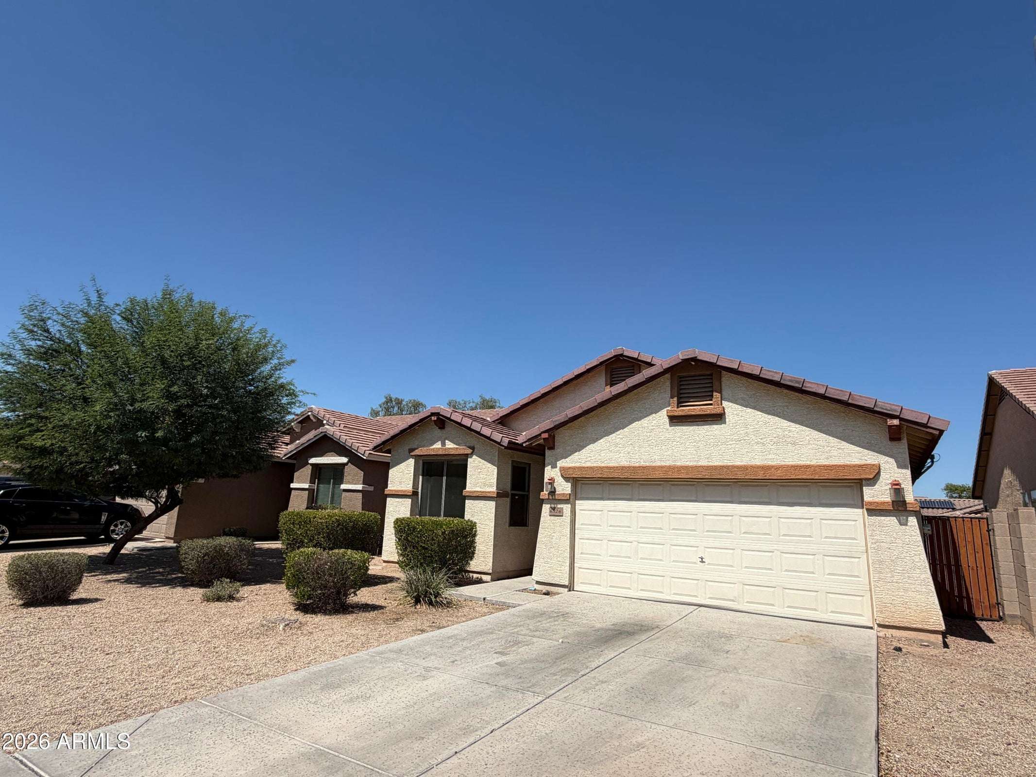 2 of 31. Inviting front entrance with an attached garage, spacious driveway, and attractive low-maintenance landscaping. Enjoy comfort and convenience at this Phoenix rental property.
