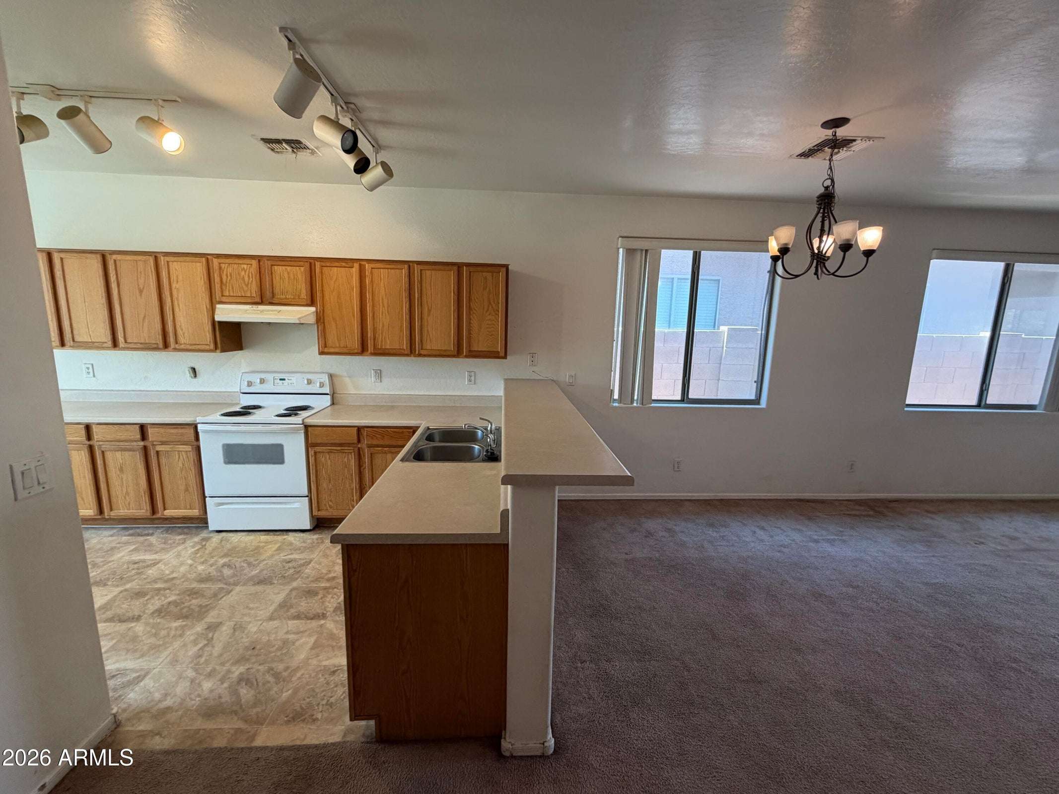 5 of 31. Open-concept kitchen with breakfast bar seating and a clear view of the spacious living area. Designed for convenience, comfort, and easy entertaining in this Phoenix rental.
