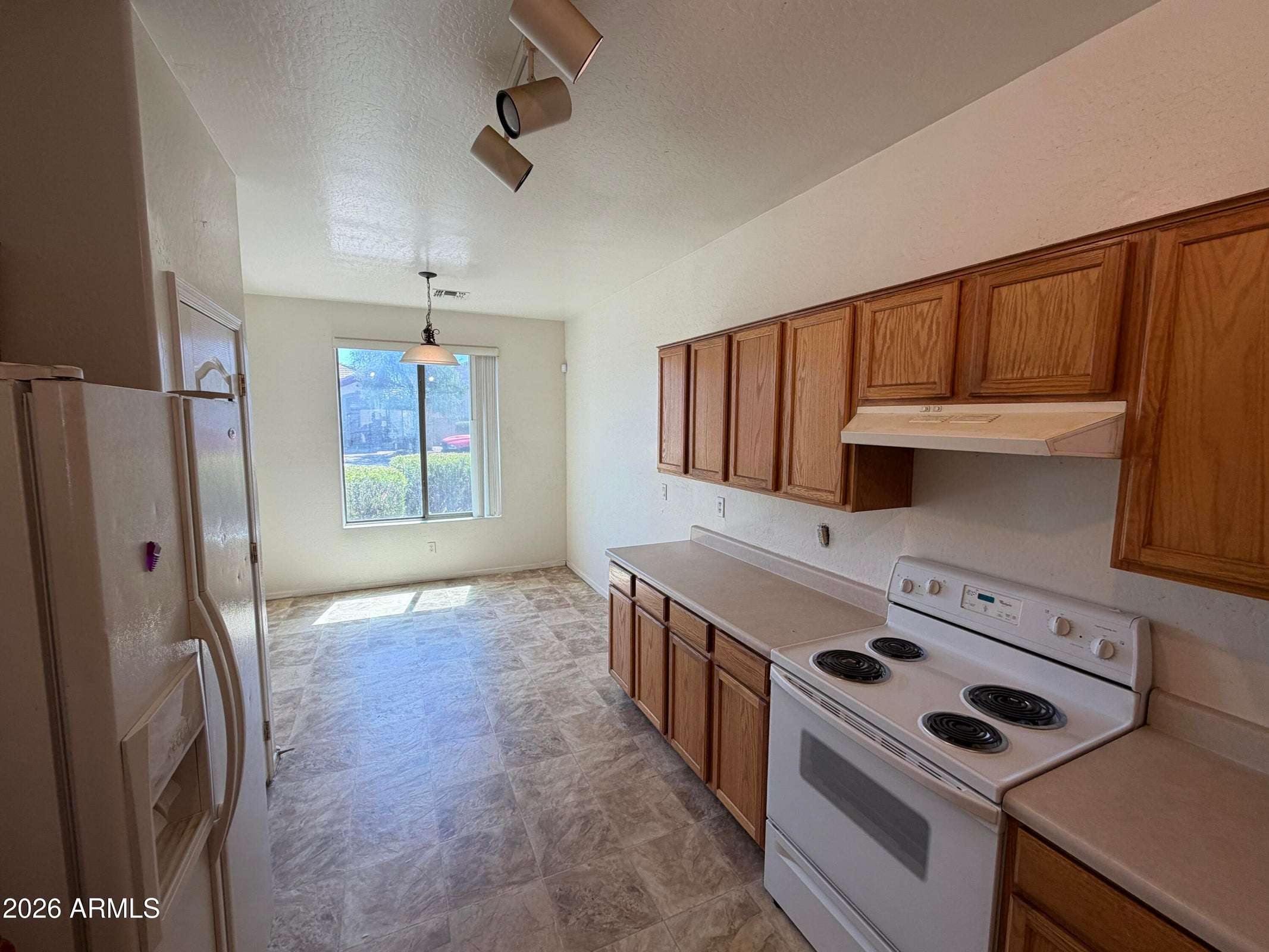 6 of 31. Functional kitchen featuring extensive cabinetry, generous countertops, and an inviting dining area with natural light. A practical layout for daily living and hosting guests.