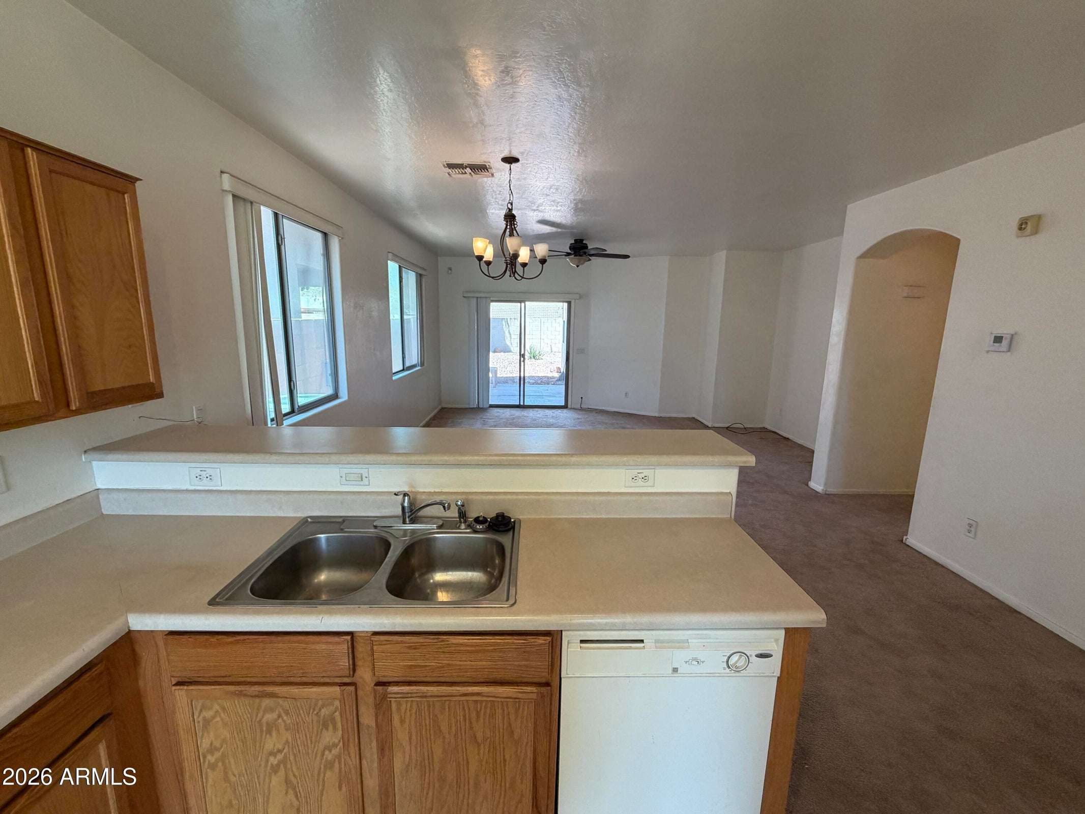 7 of 31. Spacious kitchen with breakfast bar seating, dual-basin sink, and an open layout connecting seamlessly to the living room. Ideal for entertaining and everyday convenience.
