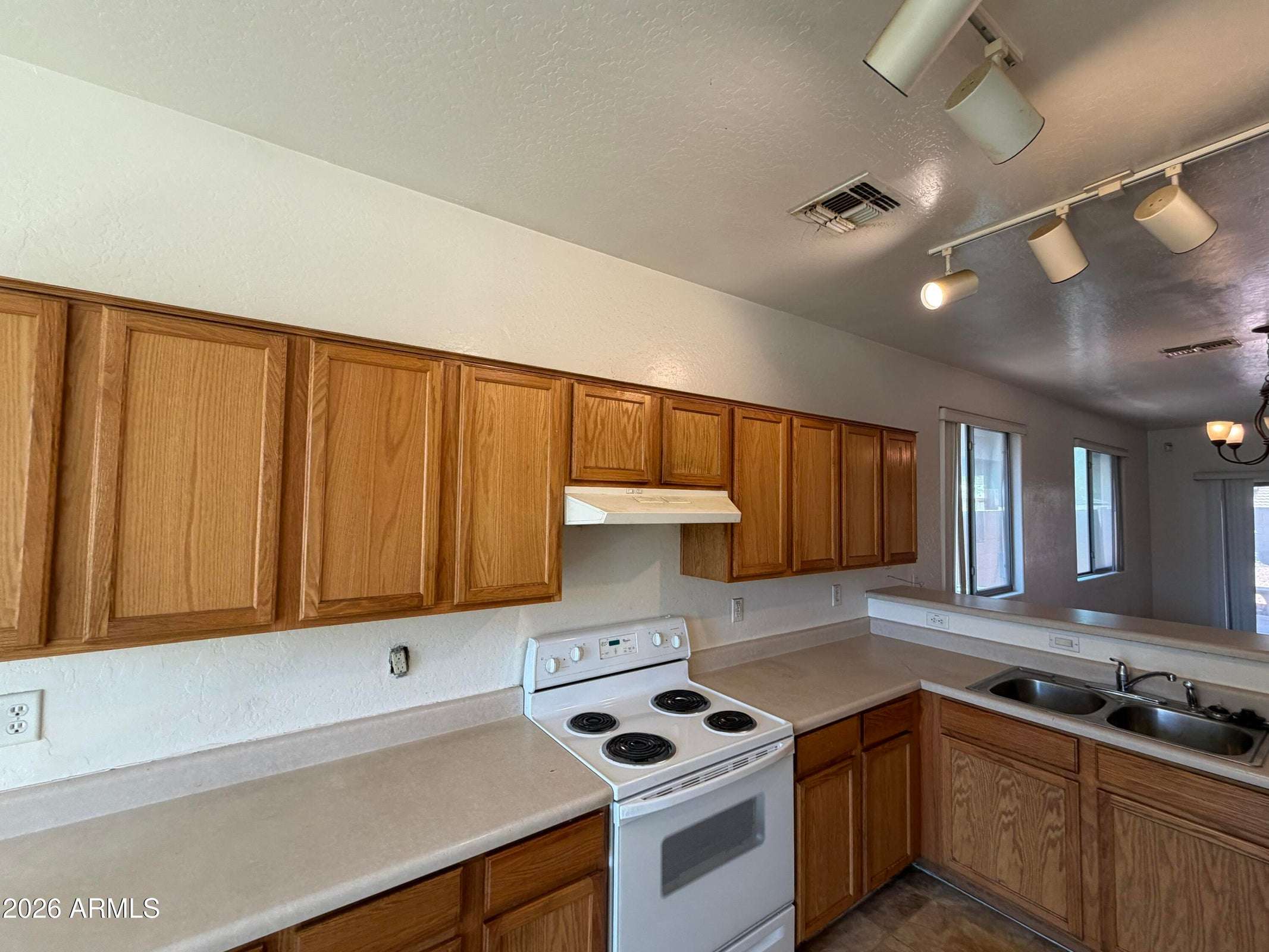 8 of 31. Well-designed kitchen offering abundant wood cabinetry, expansive counter space, and a practical workflow. The open floor plan enhances functionality and everyday comfort.